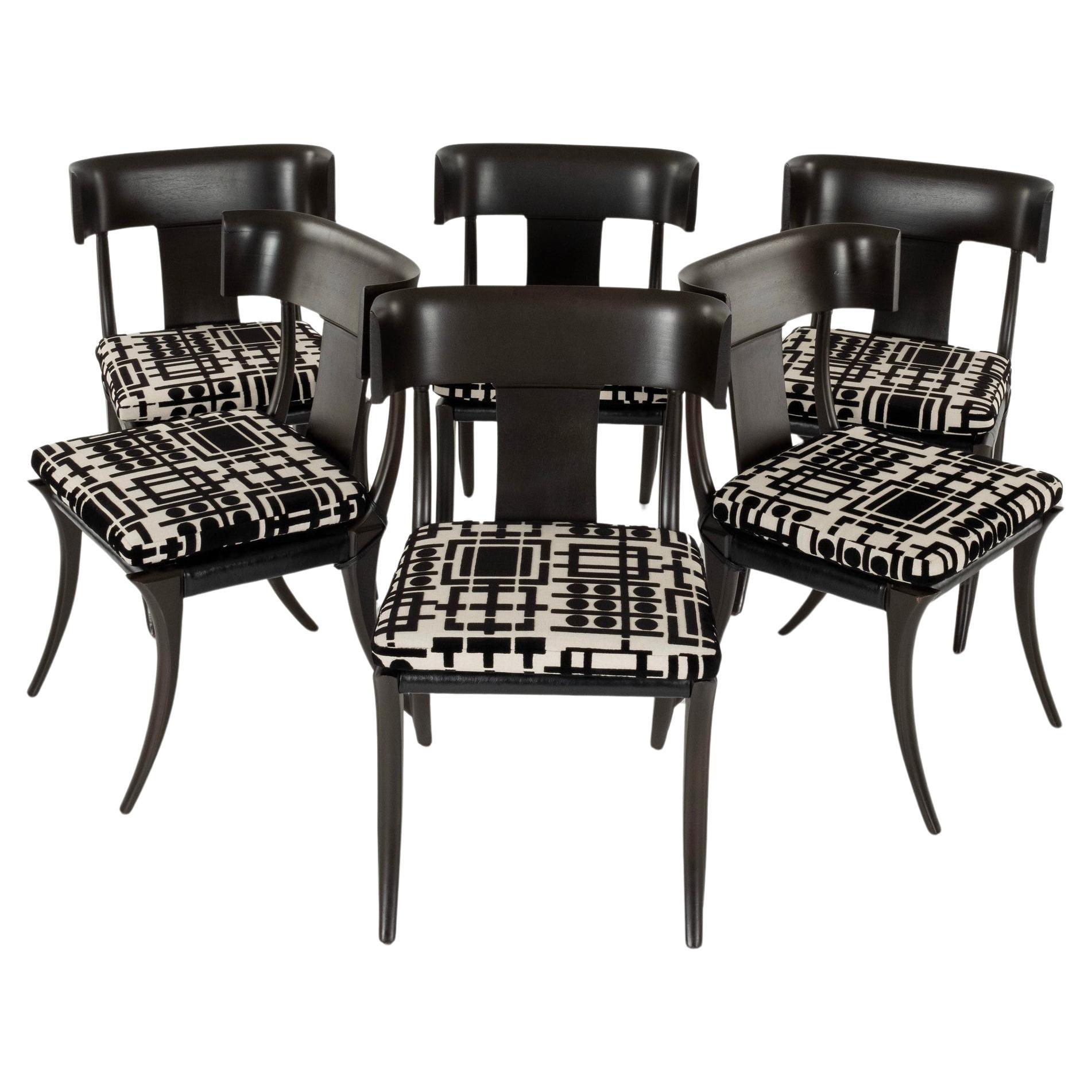 A set of six vintage Neoclassical style ebonized klismos chairs with graphic black and white cut chenille seat cushions.