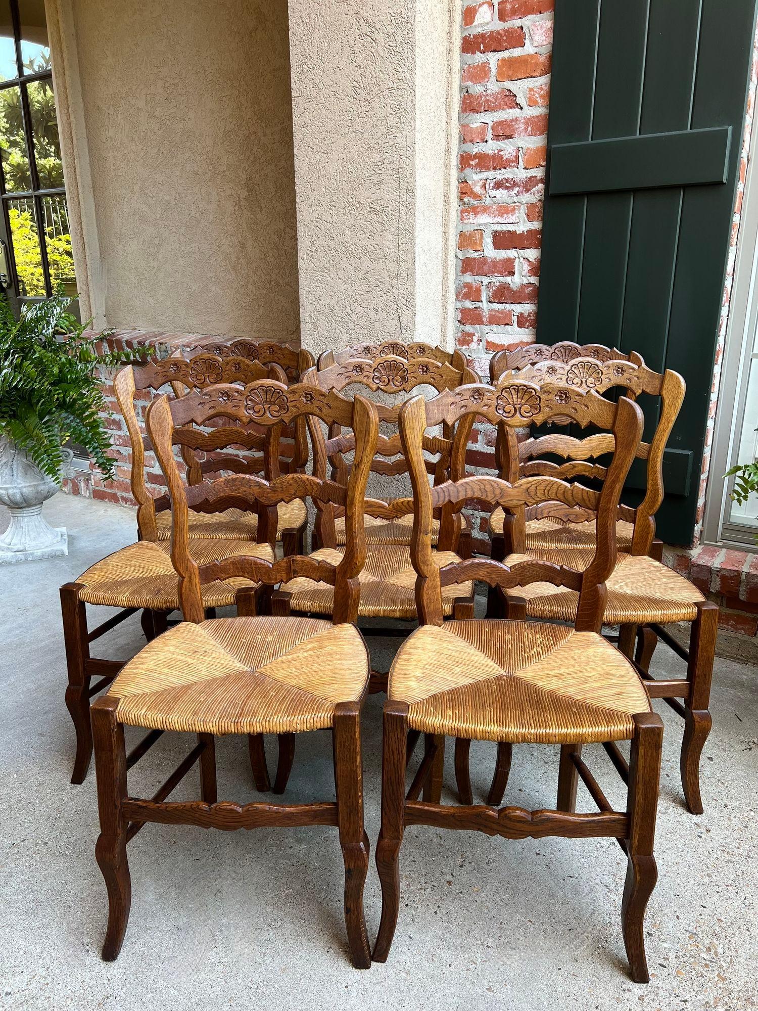 Set 8 Antique French Country Dining Chairs Carved Oak Rush Seat Ladder Back.

Direct from France, a great set of EIGHT antique French dining chairs, with classic French style…perfect for a kitchen OR dining room.
Serpentine ladder backs with a