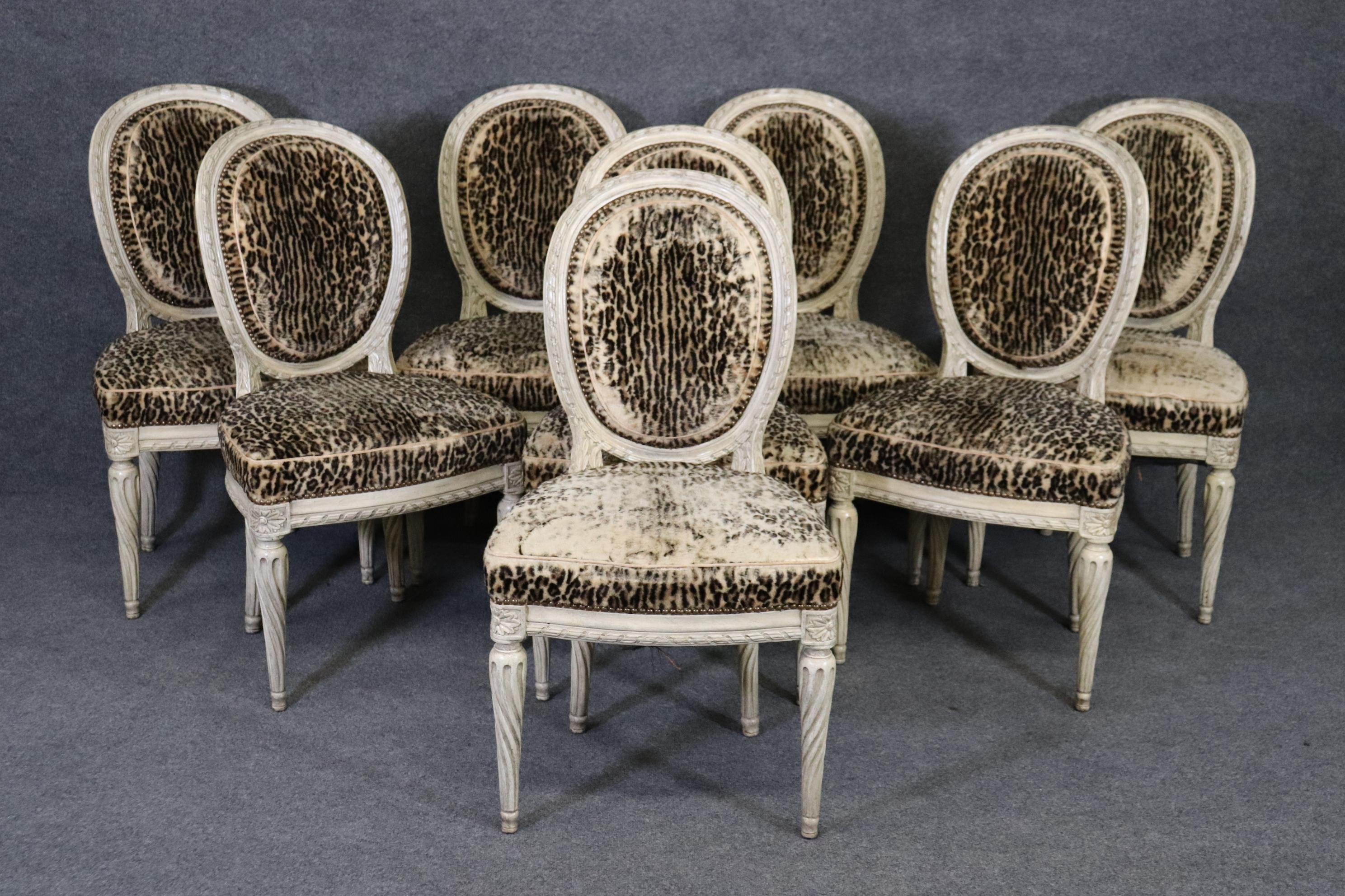This is an extraordinary set of 1940s era French-made Louis XVI or Directoire dining chairs. The chairs are in their original antique-white paint and feature gorgeous time-worn original leopard print upholstery. The upholstery is 80 years old and