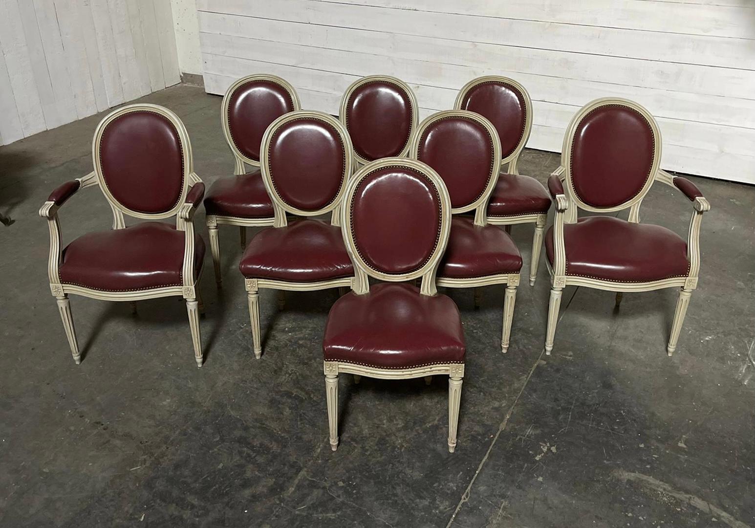 Un bel ensemble de 8 chaises de salle à manger françaises, avec une finition d'origine en blanc cassé et un revêtement en cuir d'origine qui est en très bon état, bien sûr vous pouvez l'enlever et le re-revêtir dans un tissu de votre choix. Les