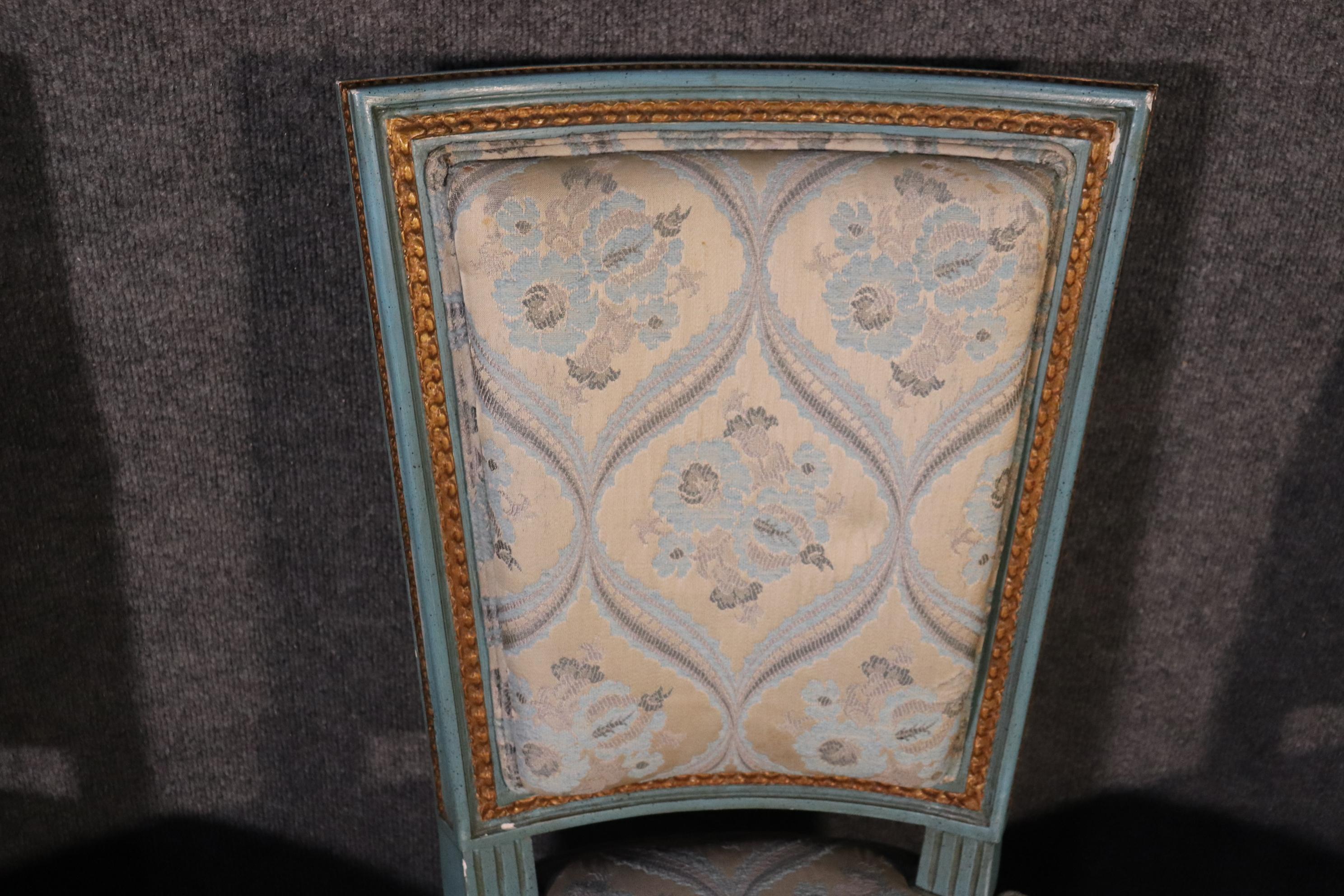 This is a stunning set of 8 French Louis XVI style dining chairs done with beautifully carved frames and gorgeous original paint and upholstery. These chairs are in good condition and have gold gilded details on the beautifully painted blue frames.