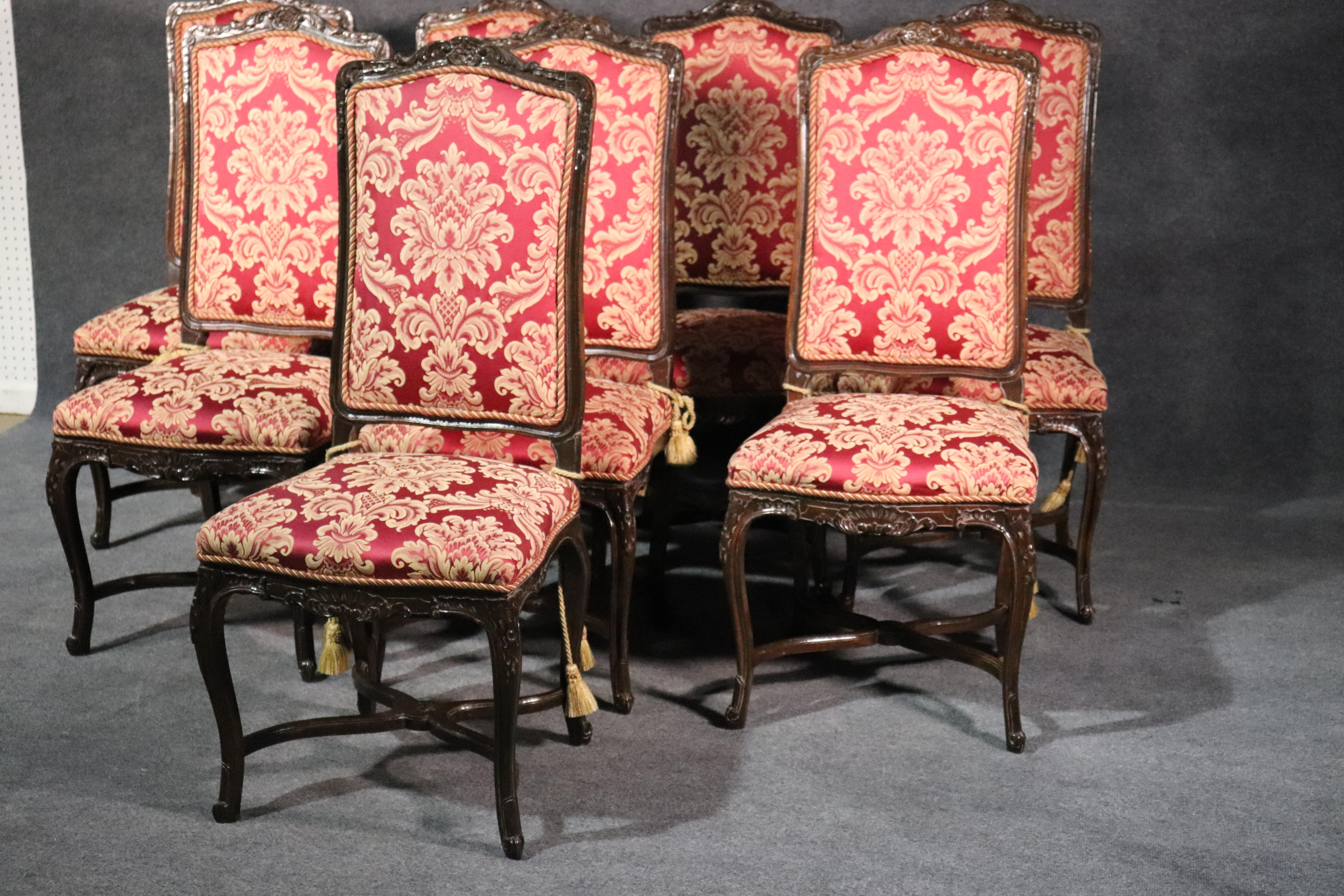 This is a fine set of 8 carved walnut French Louis XV style side chairs. They feature beautiful red damask upholstery and braided welting around the frames. The chairs are in very good condition for their age. They date to the 1950s era. 

Measure