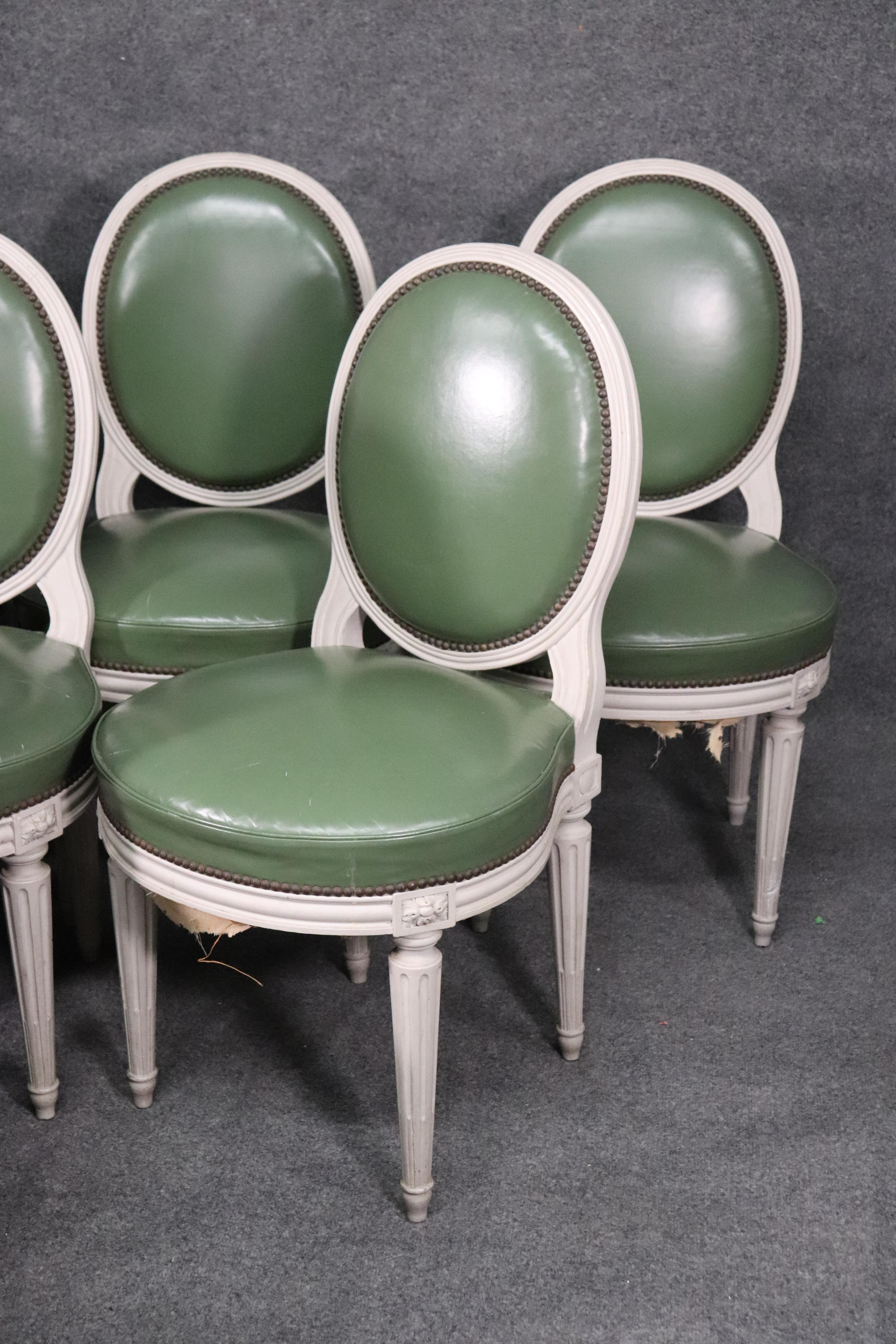 This is a fantastic set of Maison Jansen chairs, each one beautifully tailored in genuine green leather and a bright white distressed painted frame, circa 1940. The chairs are in good condition and will show signs of age and wear but nothing