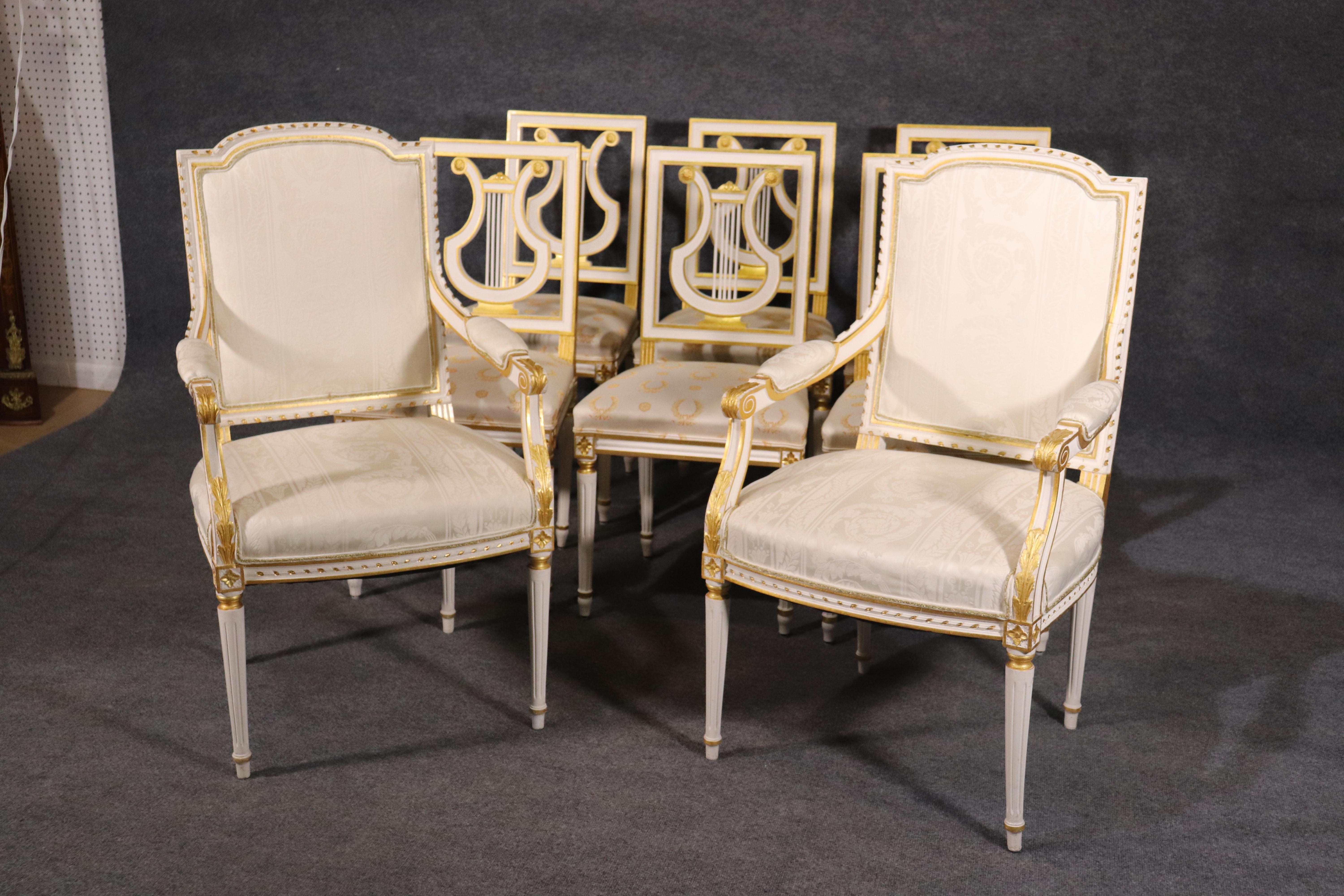 These gorgeous chairs are stamped Jansen and made in France. They feature bright white painted frames and genuine gold leaf gilded details. The upholstery is good but as they are used they are not perfect and expect some stains and minor spots here