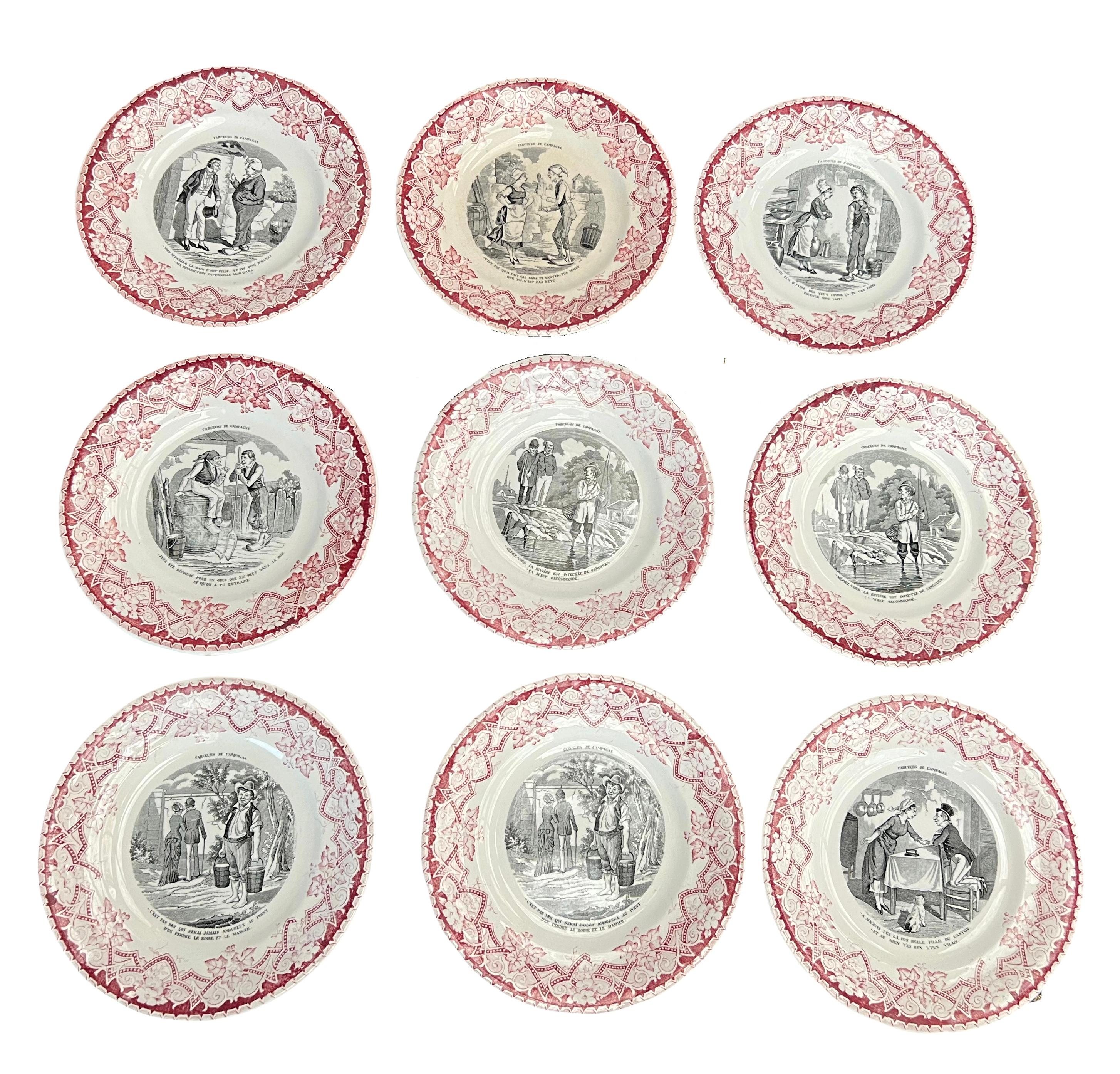 9 French Luneville faience transferware plates also known as assiette parlante or talking dish.
They come from the east of France.
They are marked on the underside with a red printed Luneville mark used since 1892 and impressed codes.

They are