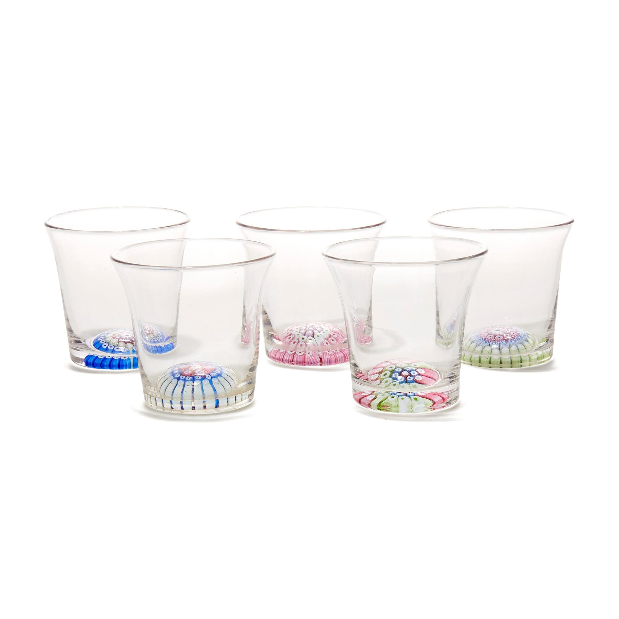A very fine set of five antique/vintage shot glasses in clear crystal with inset concentric millefiori canes to the base comprising of three rows of colored canes around a central cane. The canes form a slightly domed effect and each glass has a