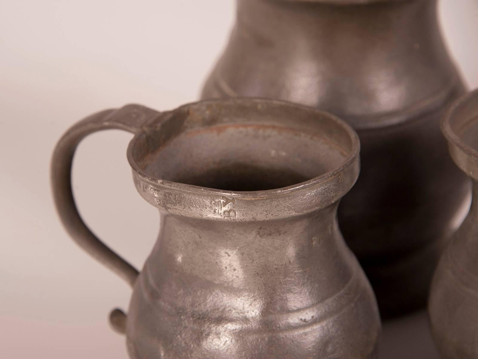 A set of eleven antique English pewter cups and pitchers with various stamps from the makers from England, circa 1850. Please look at the photographs and enlarge and zoom on them to see the hand worked detail of these pewter pieces and their