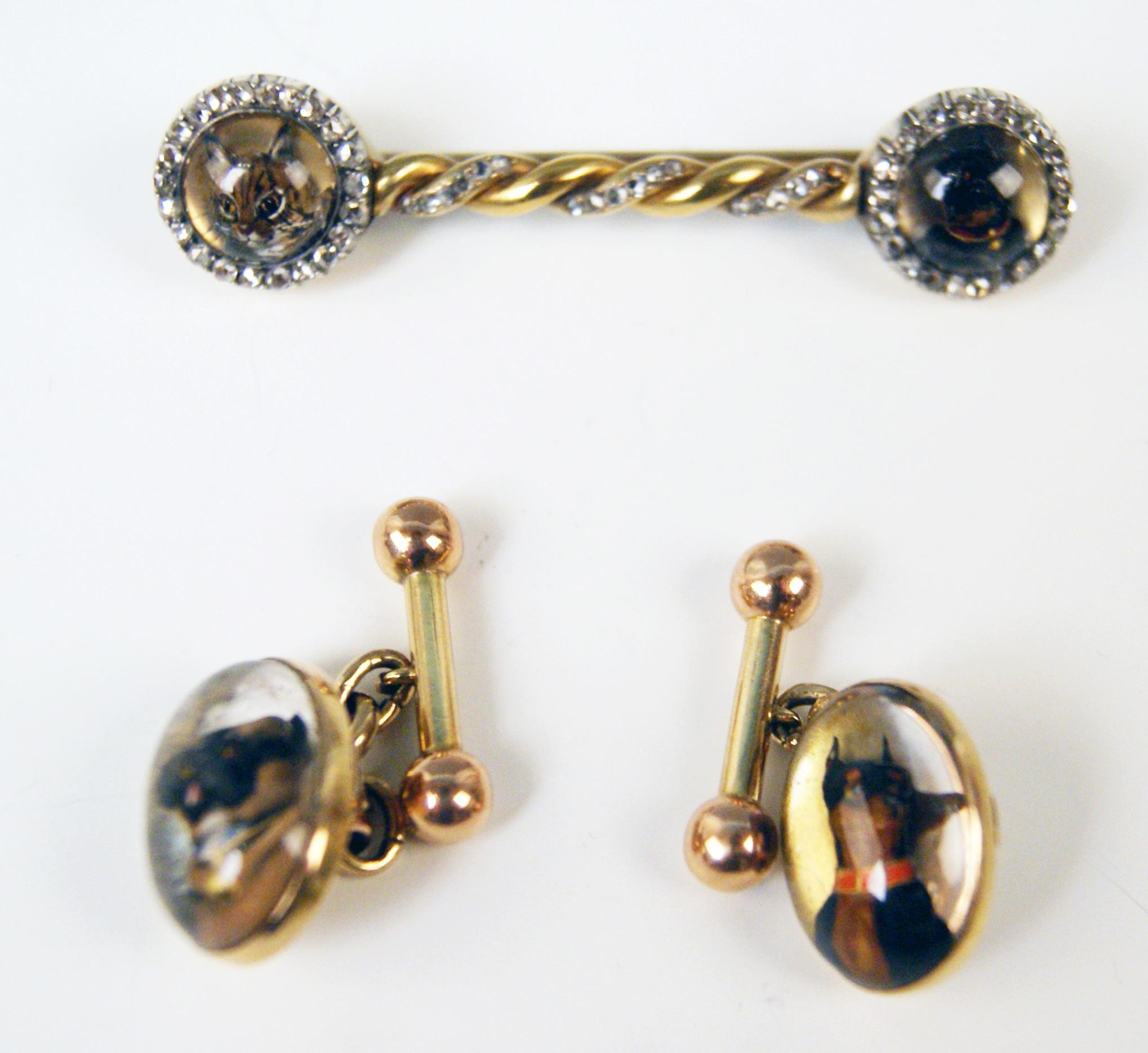 Very interesting set consisting of brooch as well as of cufflinks / studs, made at end of 19th century. 
-- The brooch consists of a wound / spiral rod with a button at each end:
Both buttons are made of cut crystal glass depicting animals' heads -