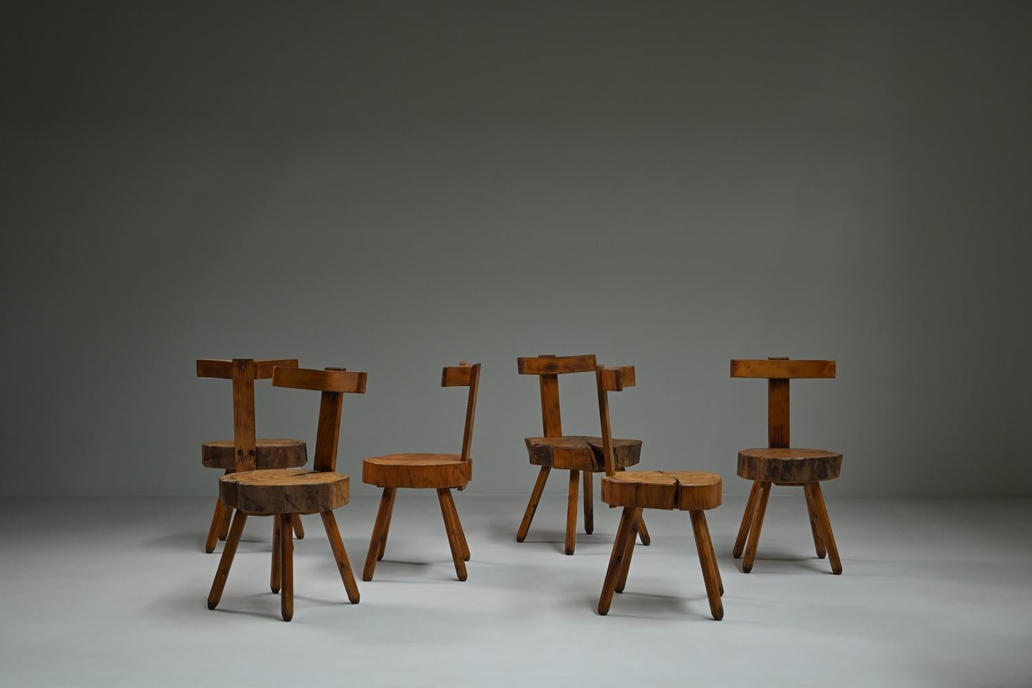 Set brutalist tree trunk chairs, 1970s France. This striking set of six Brutalist dining chairs is handcrafted from solid wood, each featuring a distinctive seat made from a cut tree trunk. The raw and sculptural design highlights the natural grain,