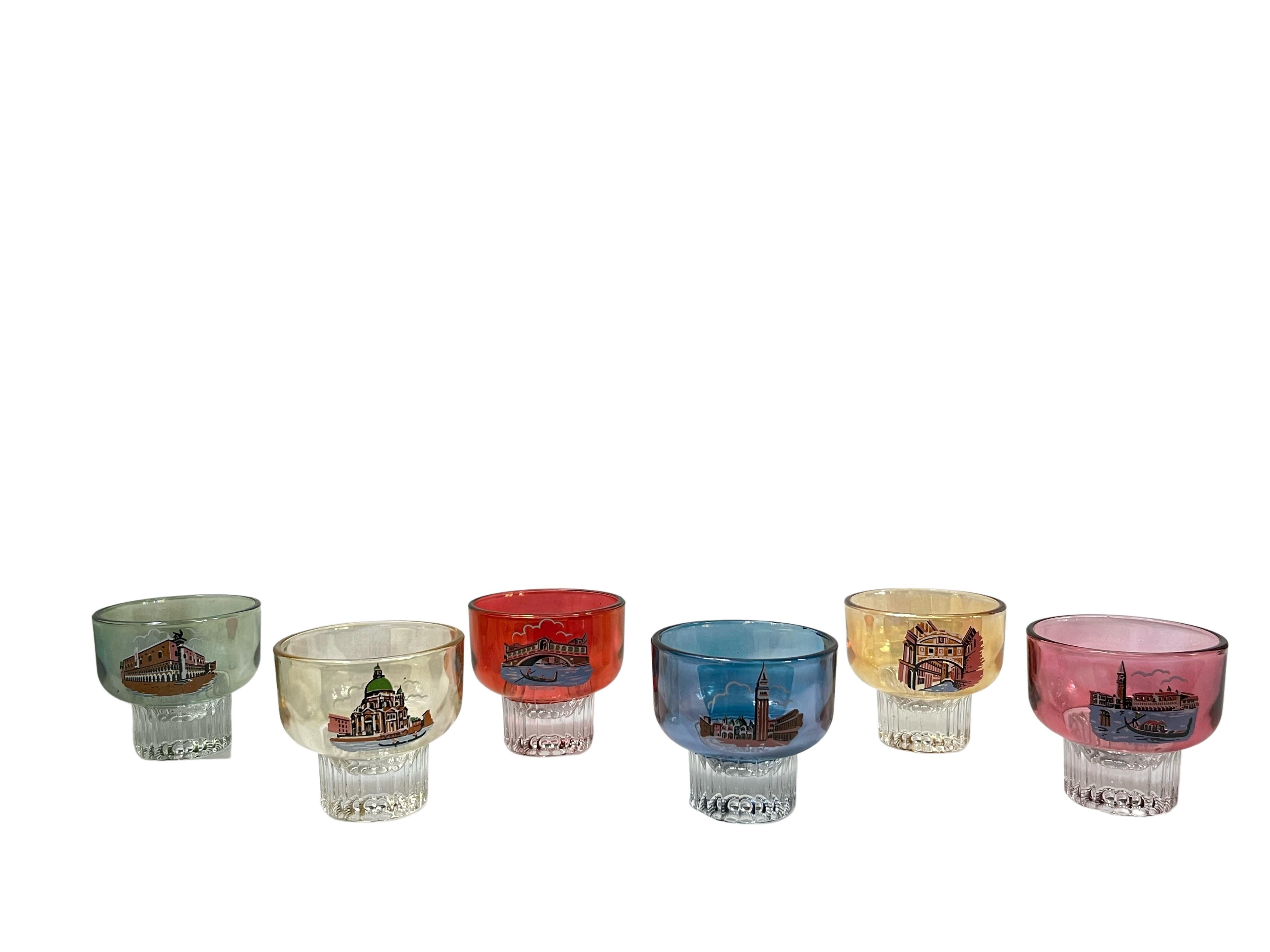 Très belle série de tasses à café / thé en verre avec la représentation des sites de Venise en Italie. 
Les coupes ont une base en forme d'étoile en verre incolore, qui se fond ensuite dans une forme bulbeuse qui a une couleur pastel différente pour
