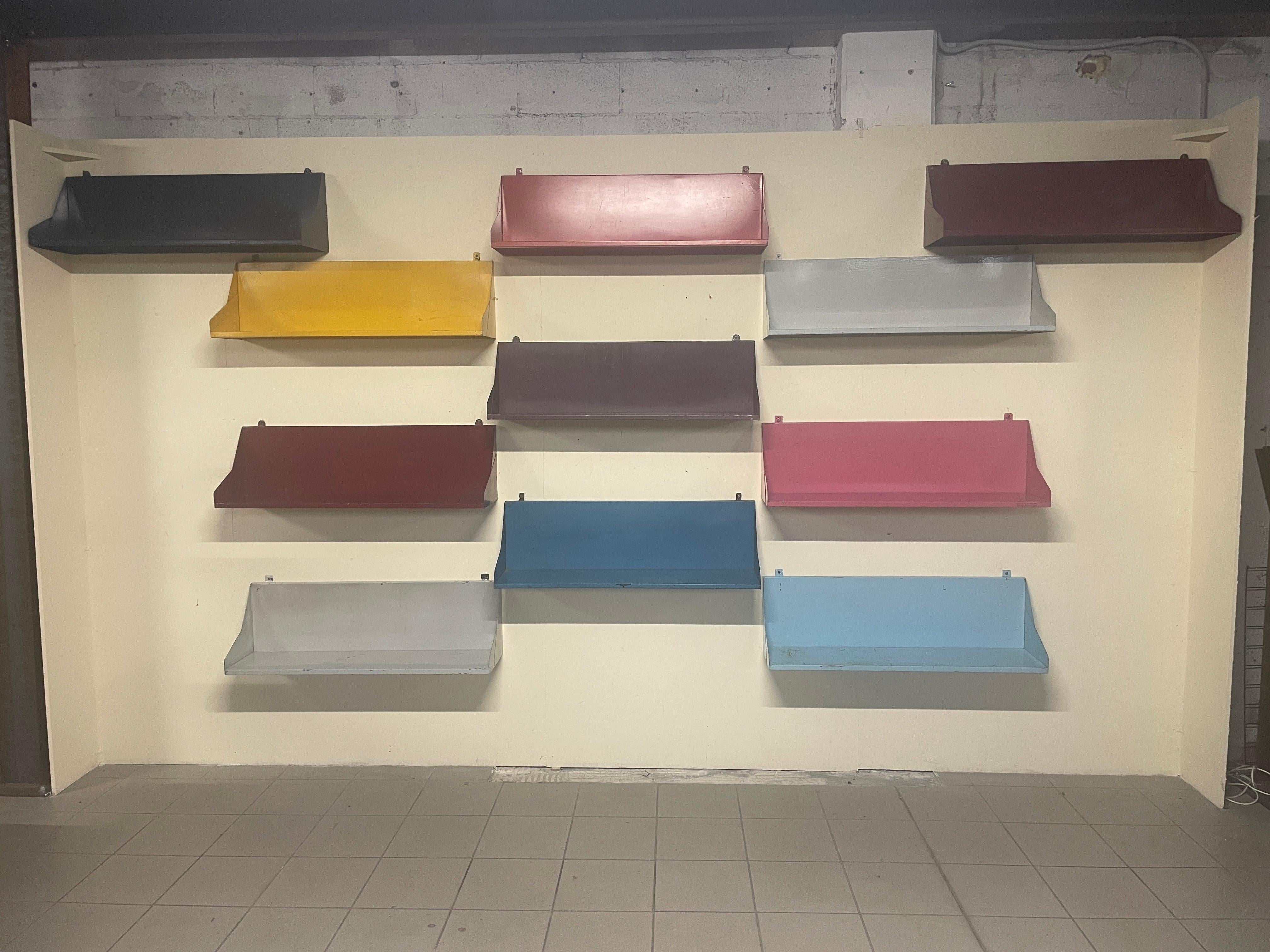 Interessanter und einzigartiger Satz von 11 lackierten und farbigen Eisenregalen aus den 1960er Jahren.

Die Farbe der Regale entspricht der Originallackierung, was den Charme dieses Sets noch verstärkt.

Die Regale stammen aus einer historischen