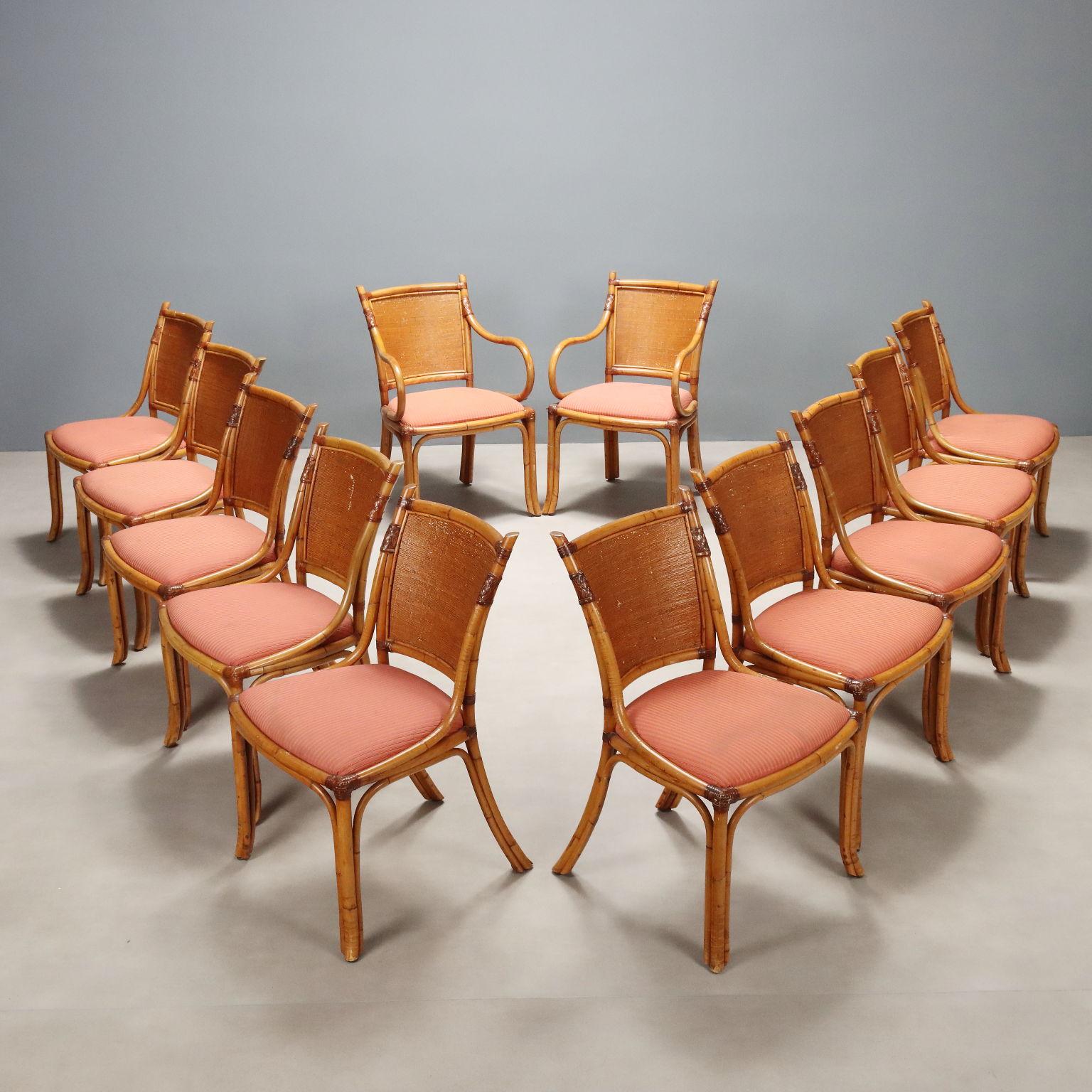 Grupo de doce sillas vintage, dos de ellas de cabecera con reposabrazos, con armazón de bambú, respaldo y asiento de mimbre con acolchado de espuma y funda original de tela en tonos salmón. Sillas listas para ser renovadas en tapicería y restauradas