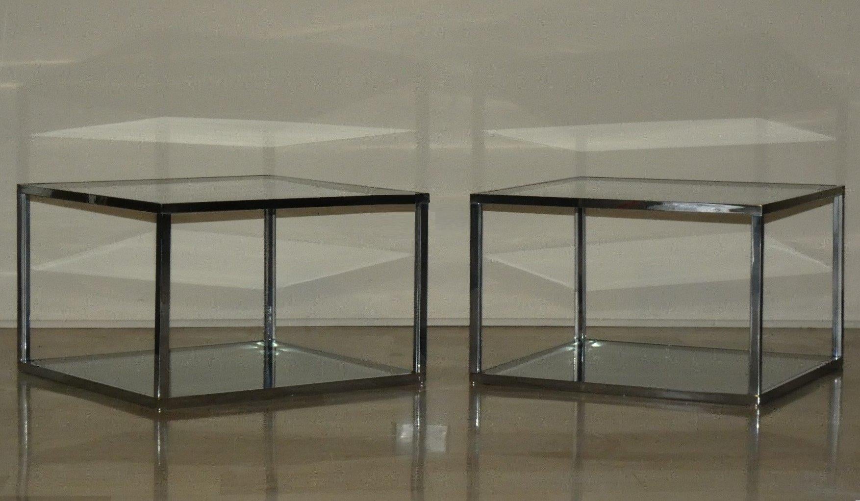 Set di due tavolini quadrati da divano.
Sono tavolini formati da una struttura minimale ed estremamente pulita nella linea.
Acciaio con placcatura cromo e due ripiani in vetro fumè.
La semplicità del design li rendono collocabili sia distanti fra