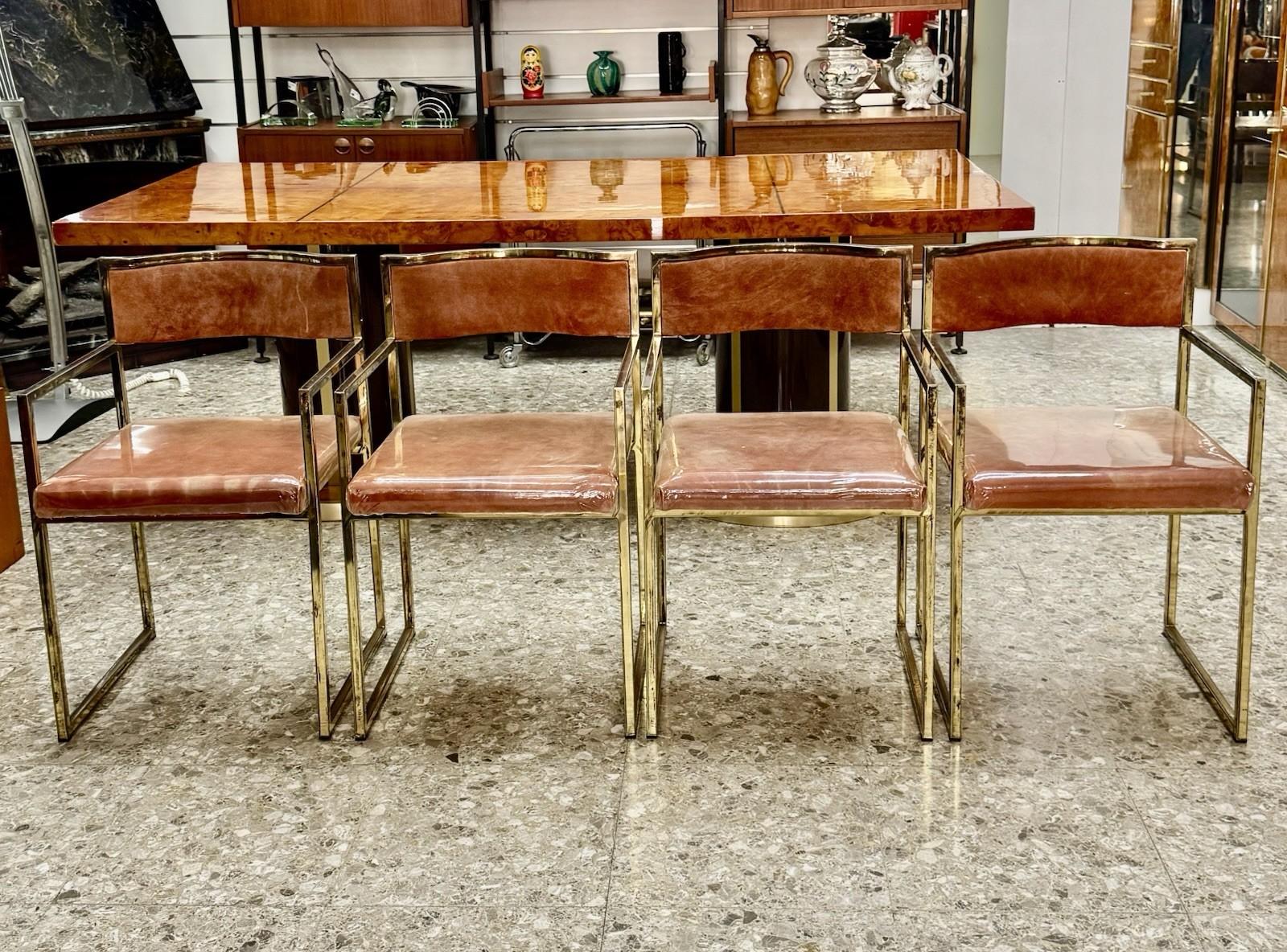 Elegante set di quattro poltroncine da pranzo originali anni ’70, in perfetto stile Hollywood Regency. La struttura geometrica in ottone dorato conferisce un tocco glamour e sofisticato, perfetto per ambienti ricercati o per aggiungere un accento