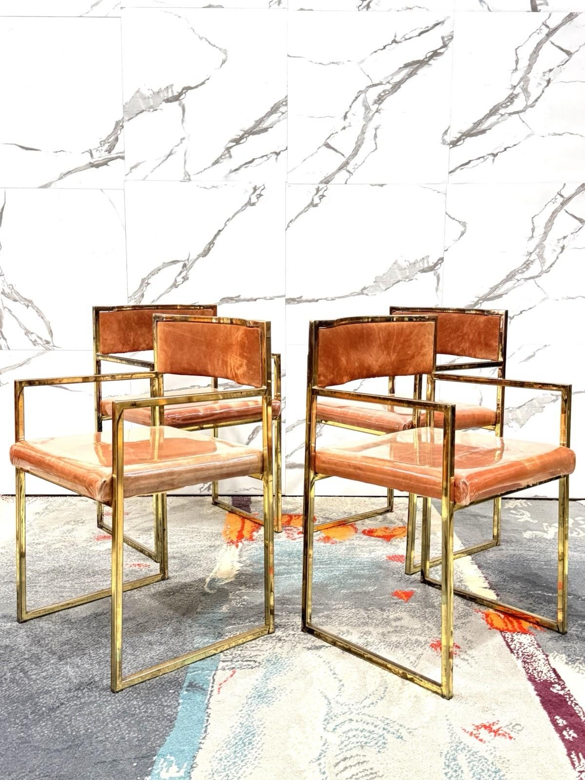 Elegante set di quattro poltroncine da pranzo originali anni ’70, in perfetto stile Hollywood Regency. La struttura geometrica in ottone dorato conferisce un tocco glamour e sofisticato, perfetto per ambienti ricercati o per aggiungere un accento