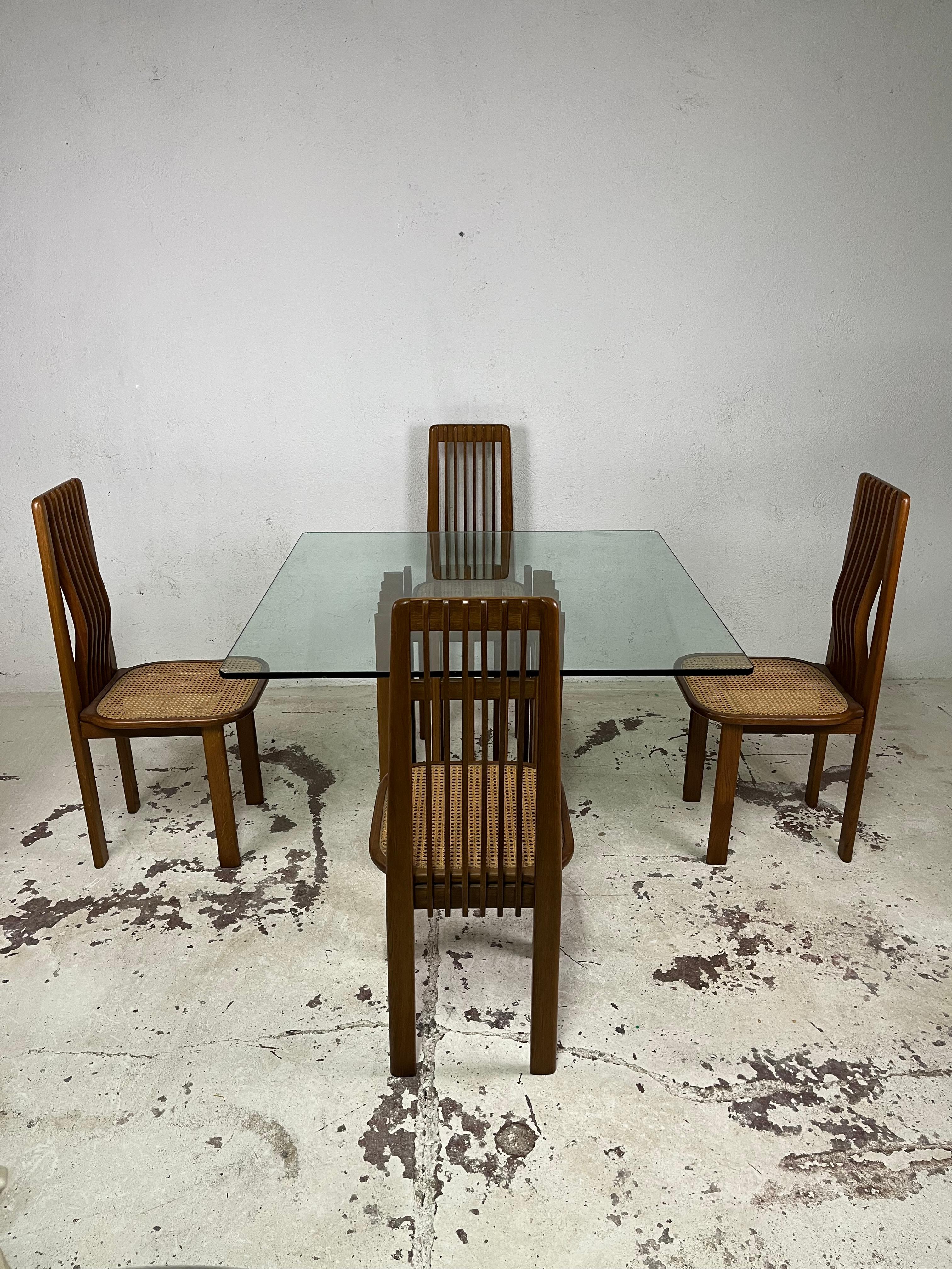 Set consisting of 4 chairs and table made of finely curved and woven maple wood, thick glass top, and Vienna straw seat of 1970s Italian manufacture.

The set is presented in excellent condition.

Table size 72 x 114 x 114 cm
Chair measurements 100