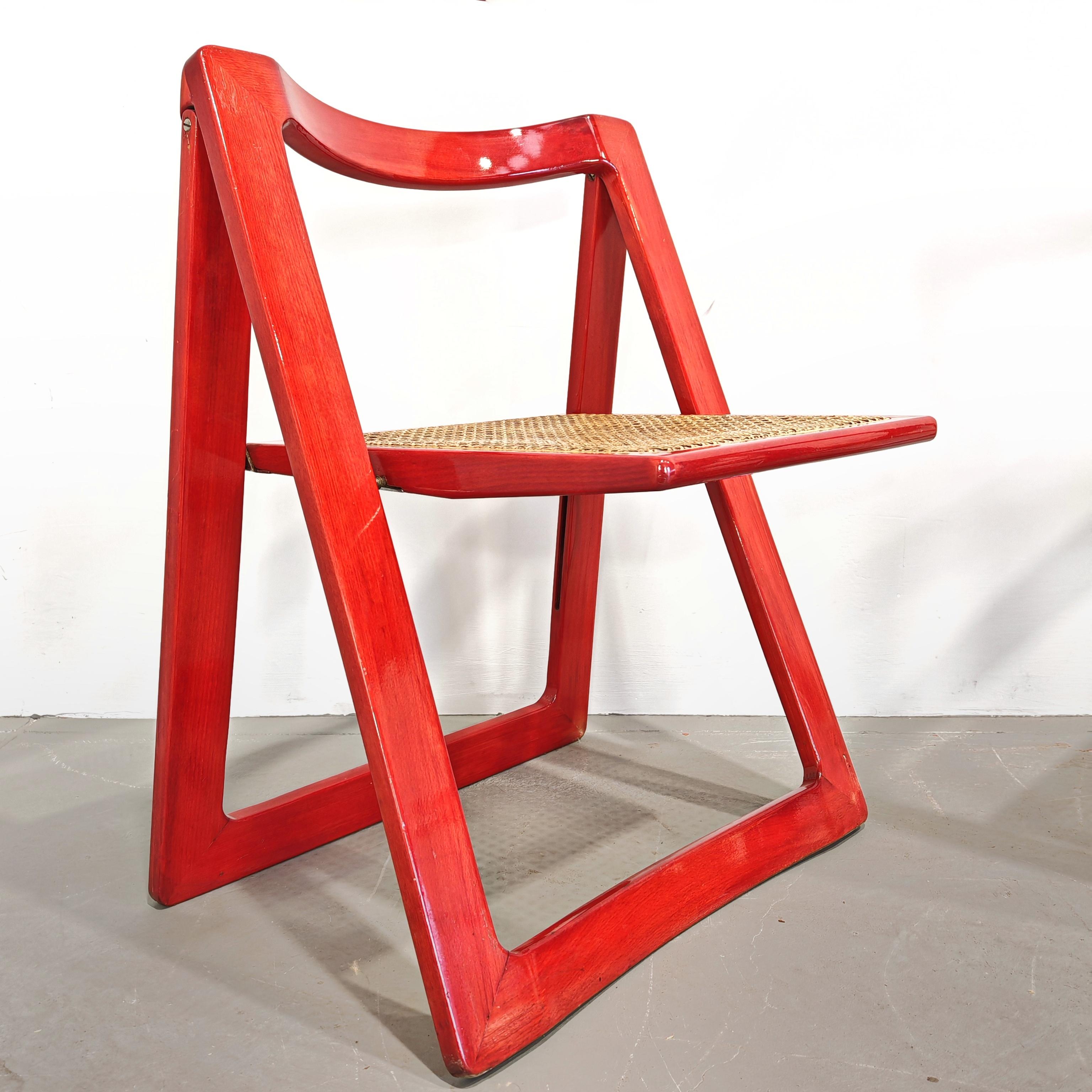 Set of 4 Trieste model folding chairs with transparent red lacquer and Vienna straw seat. The chairs are in excellent condition.
The straw is intact without hollows or breaks
The texture is flawless and the color is intact despite age with possible