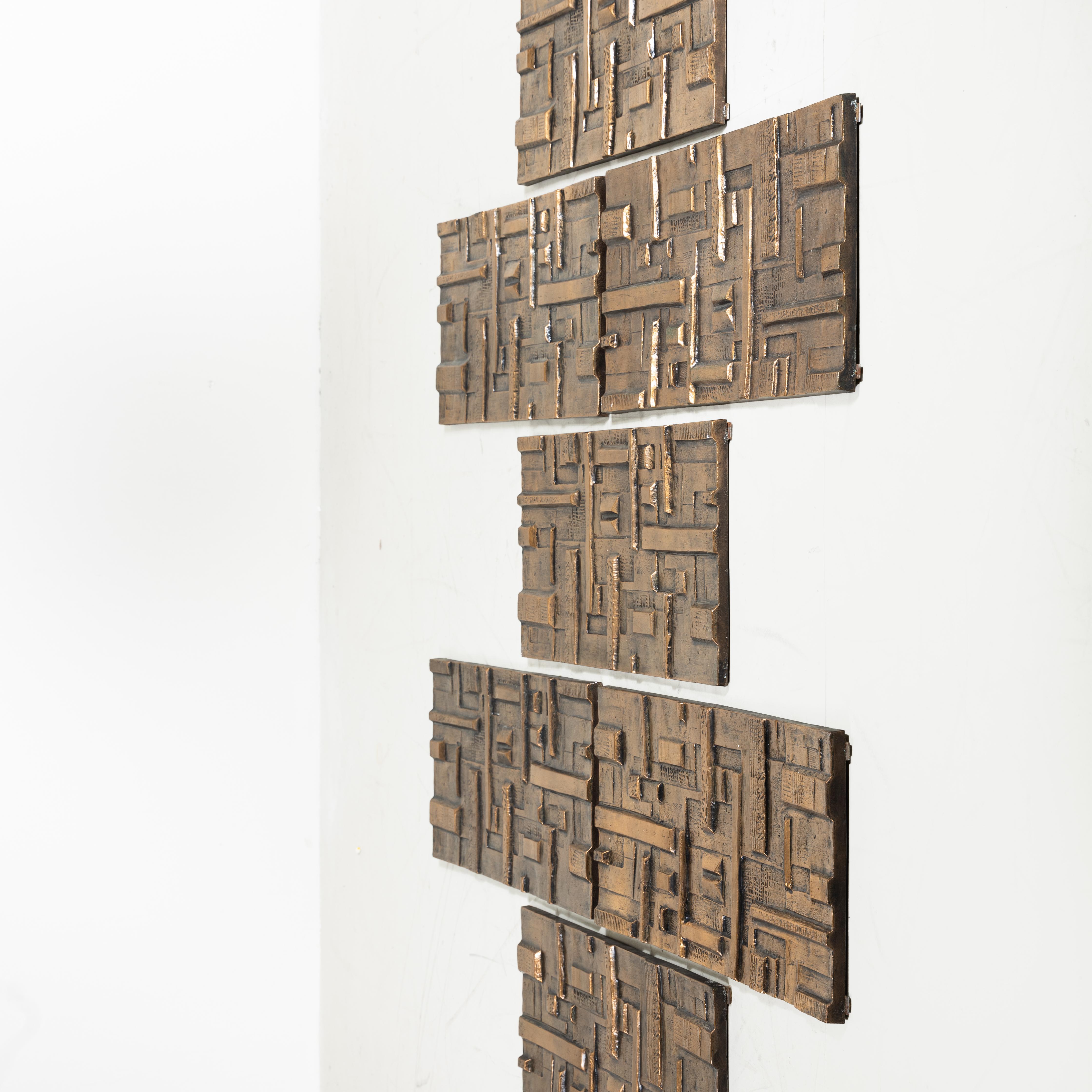 Set di 7 pannelli decorativi, stile mid-century, realizzati in resina con finitura effetto bronzo, 1970. Caratterizzati da un design scultoreo e materico, questi pannelli evocano l’estetica tipica del periodo, con superfici tridimensionali e giochi