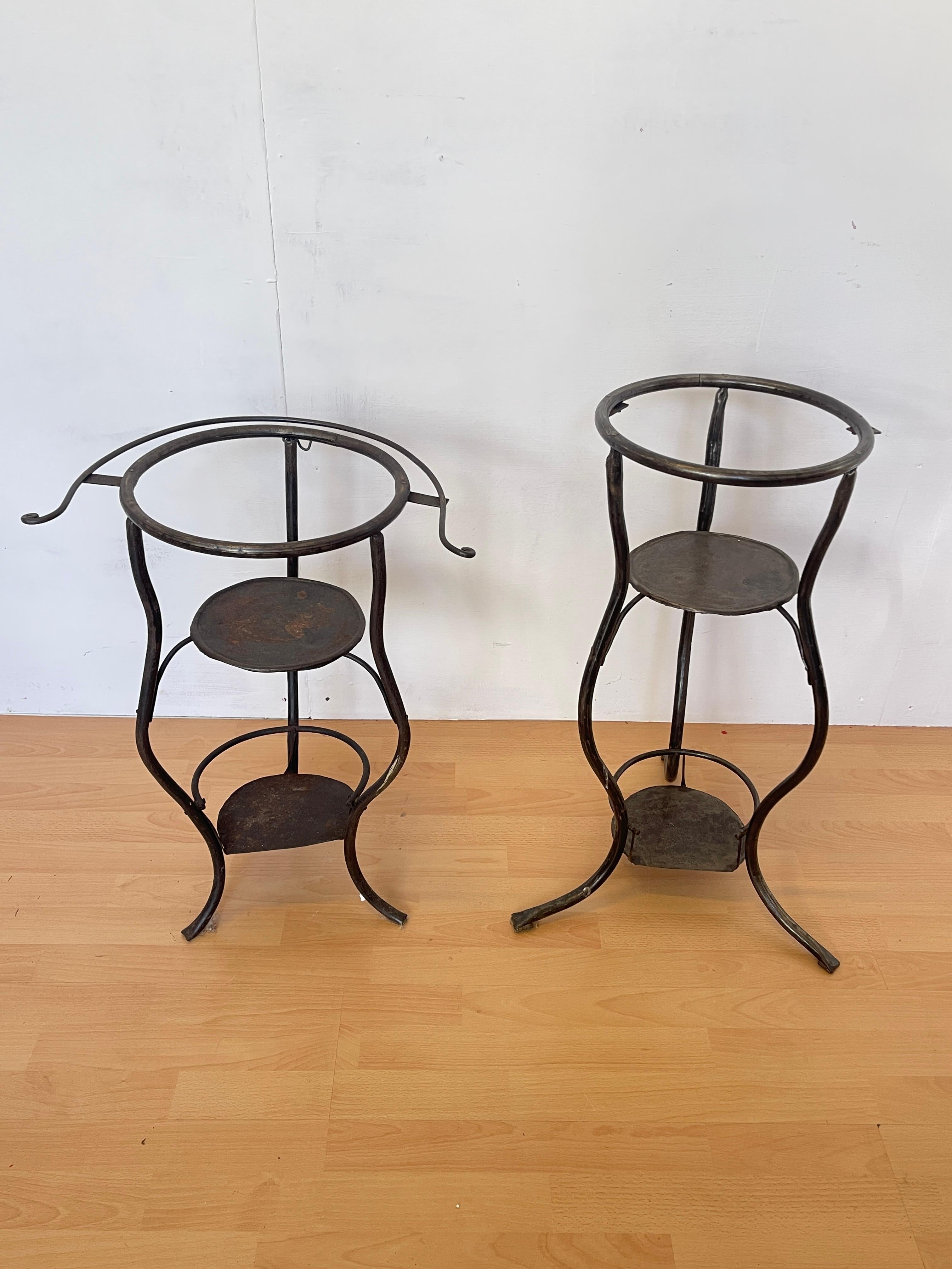 set of wrought iron bases, perfect for displaying plants and flowers. The vintage design, with iron frame and metal shelves, offers a functional and aesthetic solution for any room. These stands are ideal for the garden, terrace or entryway,