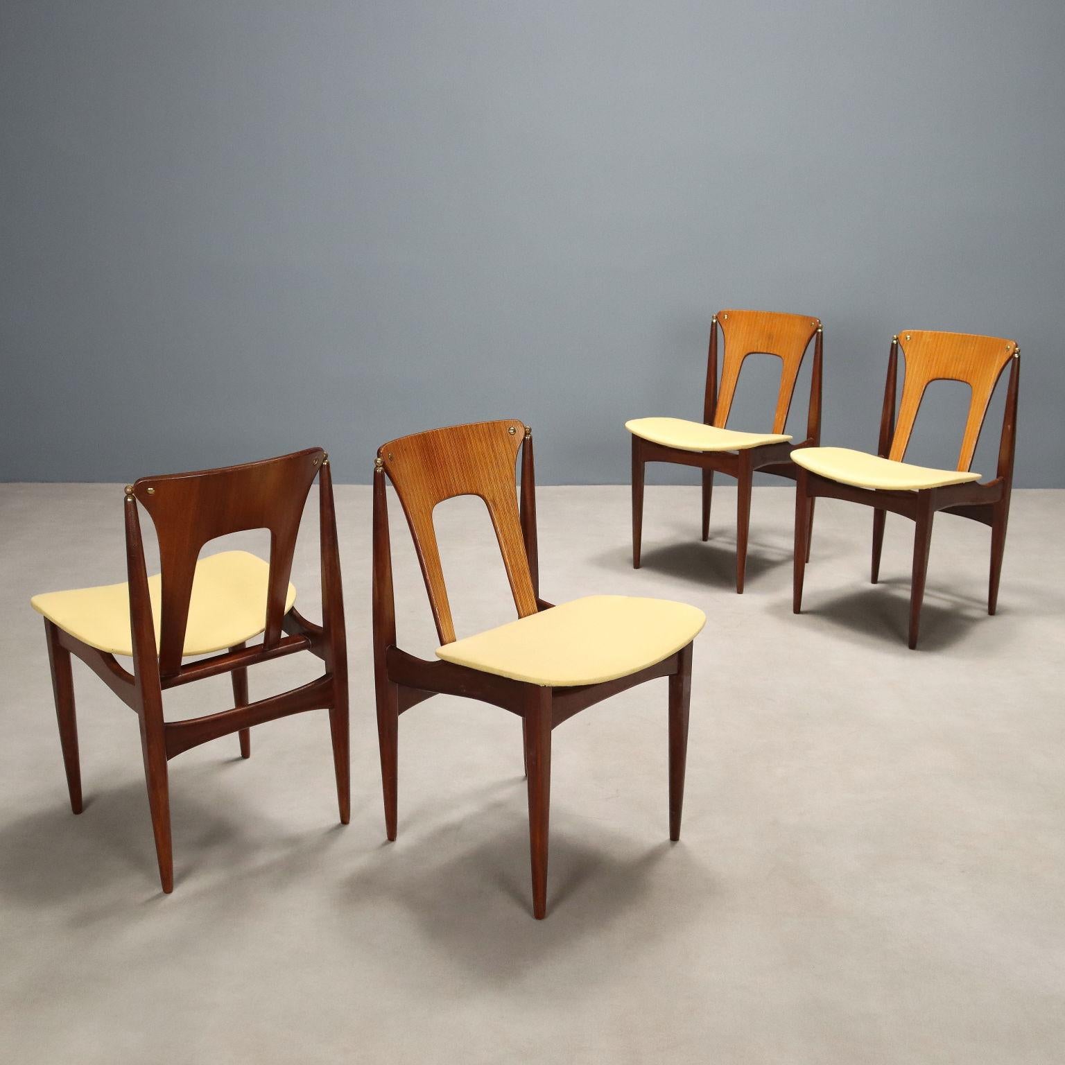 Ensemble de quatre chaises de salle à manger vintage avec structure en bois, assise en tissu dans les tons de jaune.