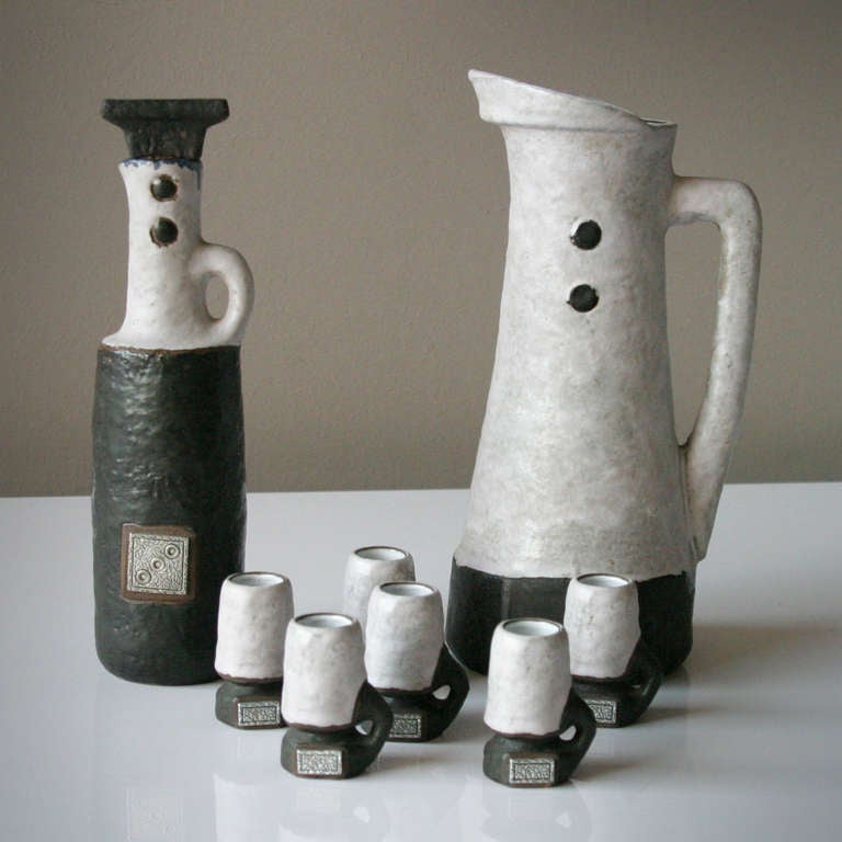 Set of ceramics, eight pieces; one jug, a decanter and six cups. The 'Domino series', design by Hans Welling for Ceramano. Lost of the silver 'domino stone' on the jug. Signed with: '55/51 Domino Ceramano W. Germany Handarbeit'.
Measurements: