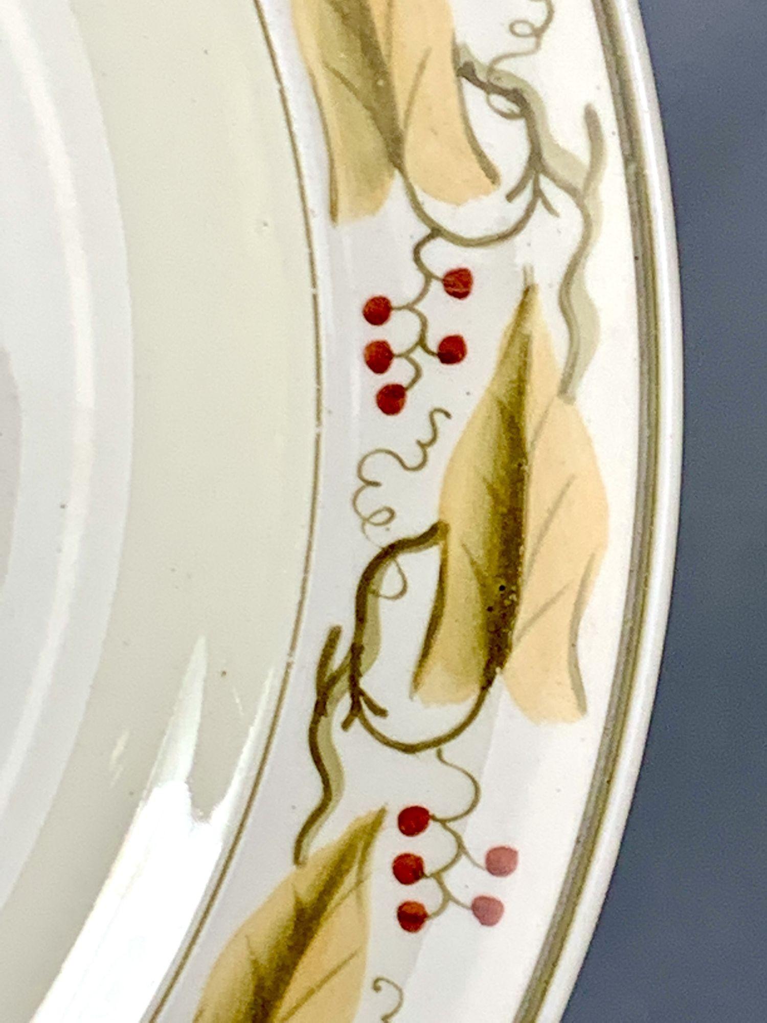 Made in 1904, the border design on this set of Wedgwood dinner dishes was inspired by designs in Josiah Wedgwood's mid-18th century First Pattern Book.
The red berries and beige leaves on the vine combine perfectly with the creamy color of the