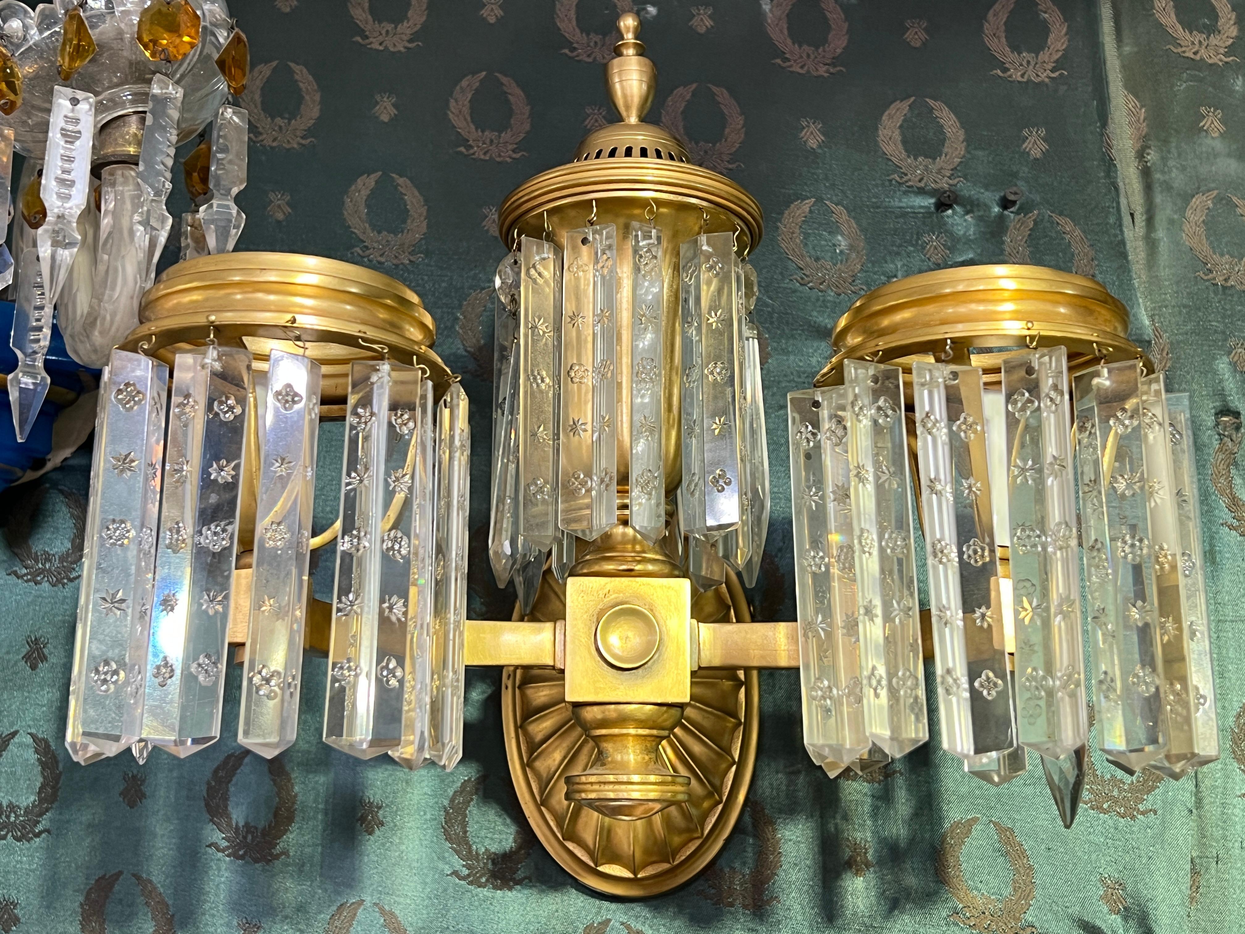 Ensemble de quatre appliques anciennes (début du 20e siècle) en bronze doré et cristal dans le style Regency anglais, chacune mesurant 13 par 13 par 6 pouces, avec des douilles de taille candélabre, des couvercles de bougie blancs et le câblage,