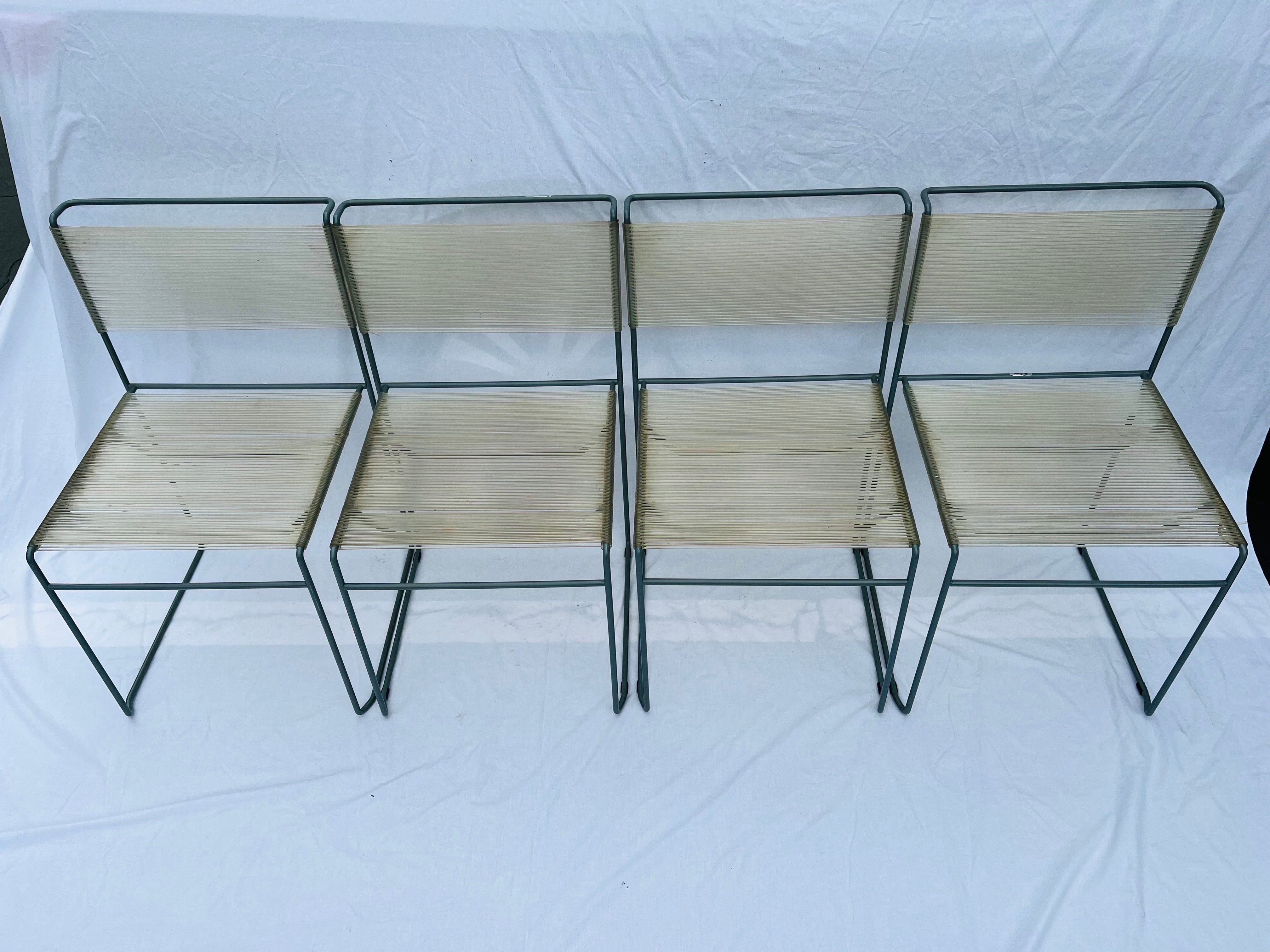 A vintage set of four circa 1970's first edition Fly Line Spaghetto chairs. These spaghetti strap style chairs have great post modern style metal frames. The PVC tubular strap seats and backs are in a semi translucent color. The paint coated metal