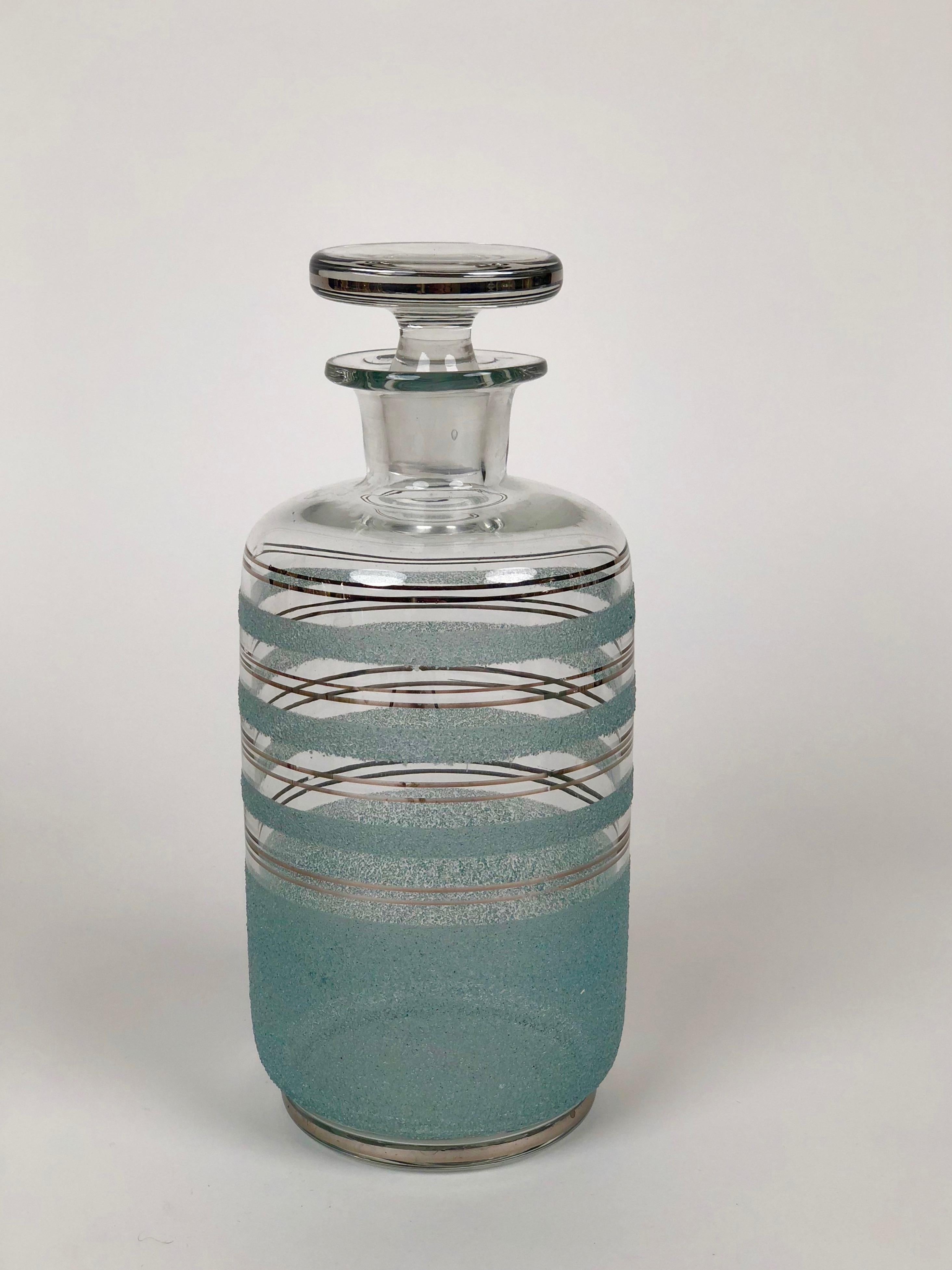 Satz von drei Glaskaraffen für Destillate aus den 1930er Jahren, hergestellt in der Tschechoslowakei.
Die Karaffen sind mit silbernen Streifen verziert, die grünen Streifen sind farbig
glas, das an der Karosserie befestigt wurde.

Sie können es für