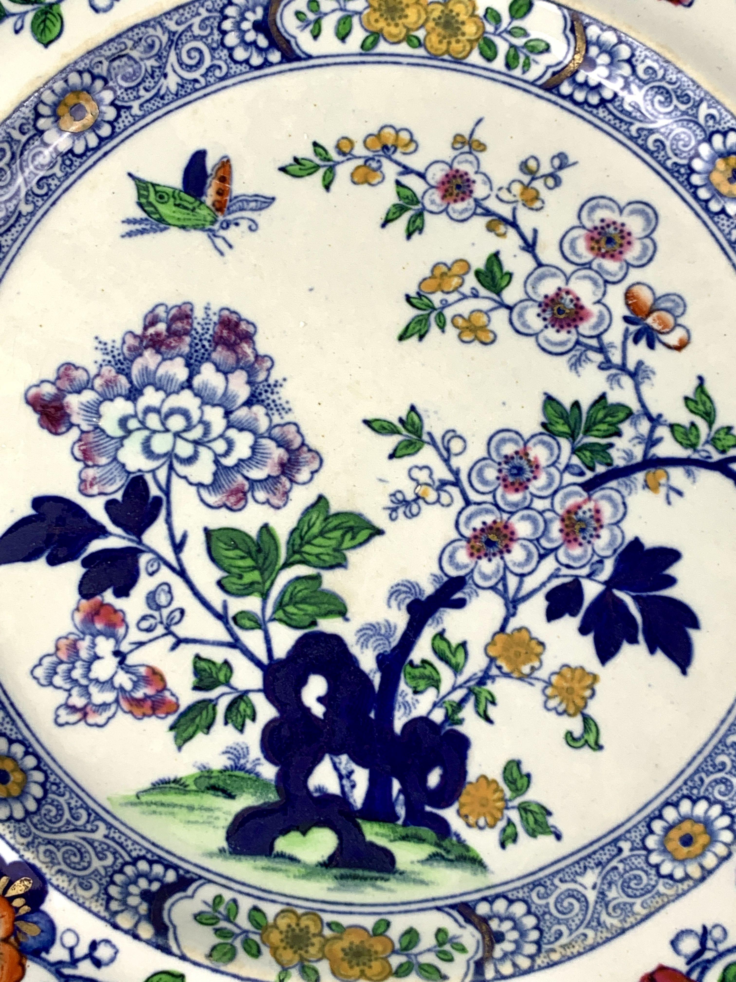 Made by Hicks and Meigh, this set has six dinner dishes and five matching soup dishes.
The decoration is lovely: a butterfly hovers above a flower-filled garden.
We see purple peonies and pink fruit tree blossoms emanating from cobalt blue