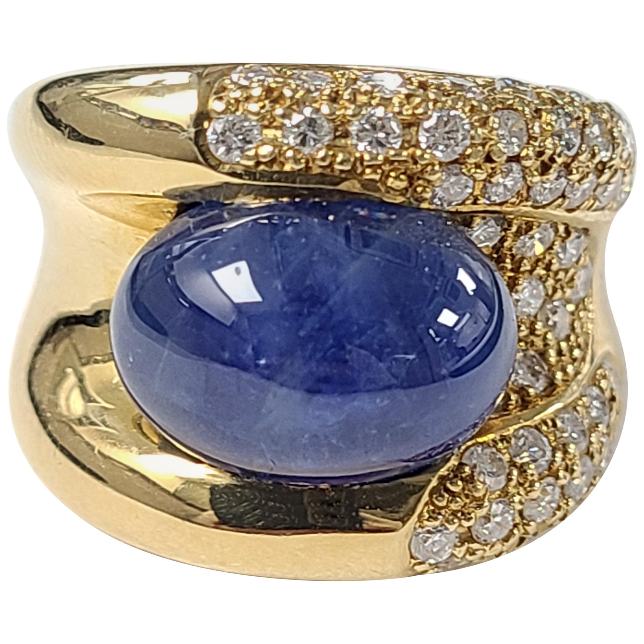 An Elegant ring set in 18k gold with blue sapphire cabochon and diamonds . the blue sapphire weight is 11.16 carats and diamond weight is 1.06 carats . The ring dimensions in cm 1.5 x 2.2 x 2.4 ( L X W X H ). US size 6