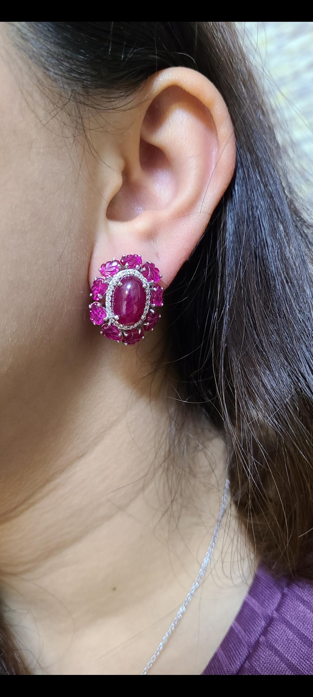 A stunning pair of carved & cabochon Ruby Stud Earrings set in 18K gold and Diamonds. The rubies, are completely natural, without any treatment and originate from Mozambique. The weight of the Rubies is 21.81 carats. The leaf carved Ruby is