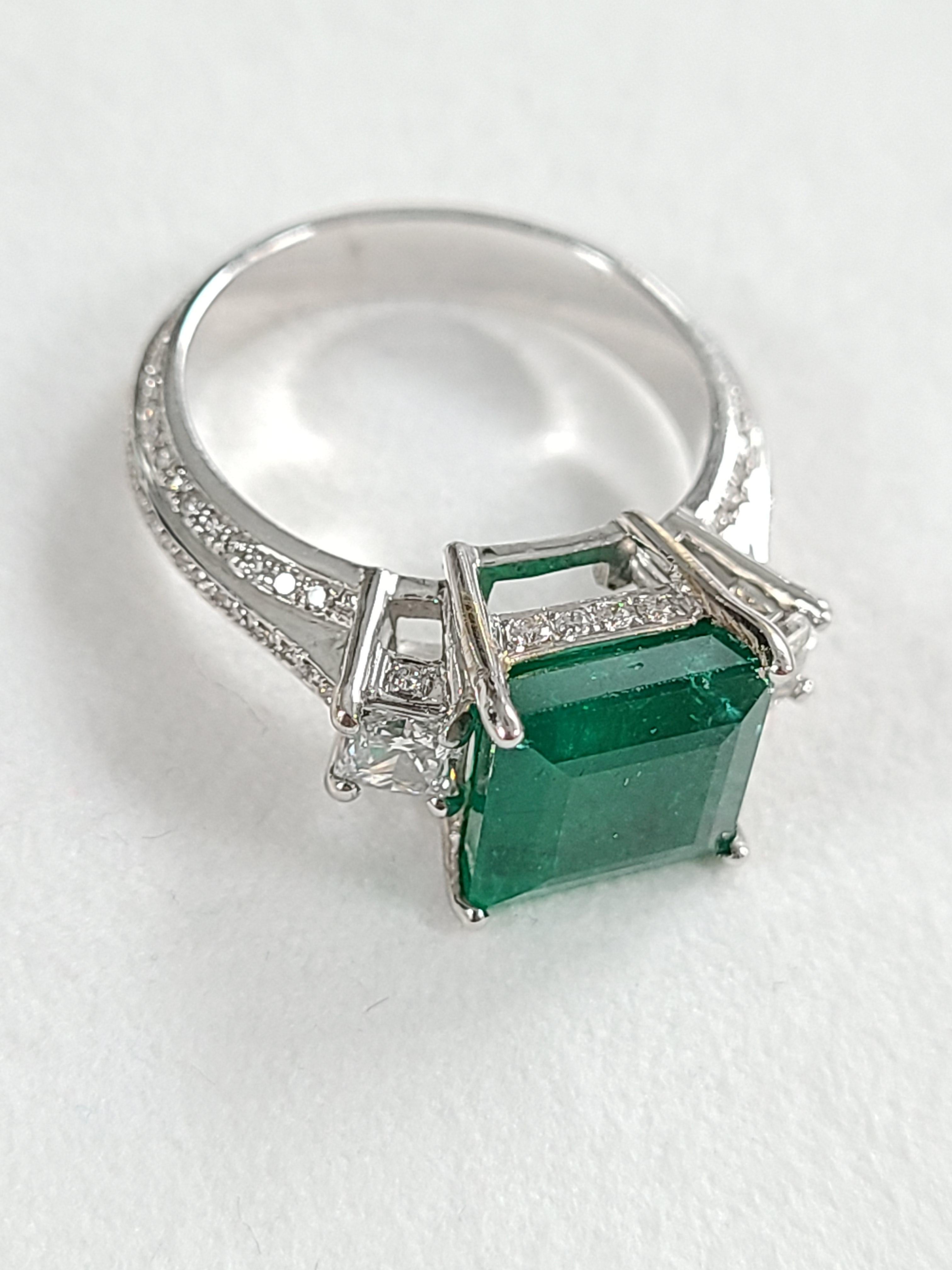 A very wearable, everyday Square Emerald & Princess Diamonds Engagement Ring set in 18K Gold. The weight of the Emerald is 3.97 carats. The Emerald is completely natural without any treatment and originates from Zambia. The combined weight of the