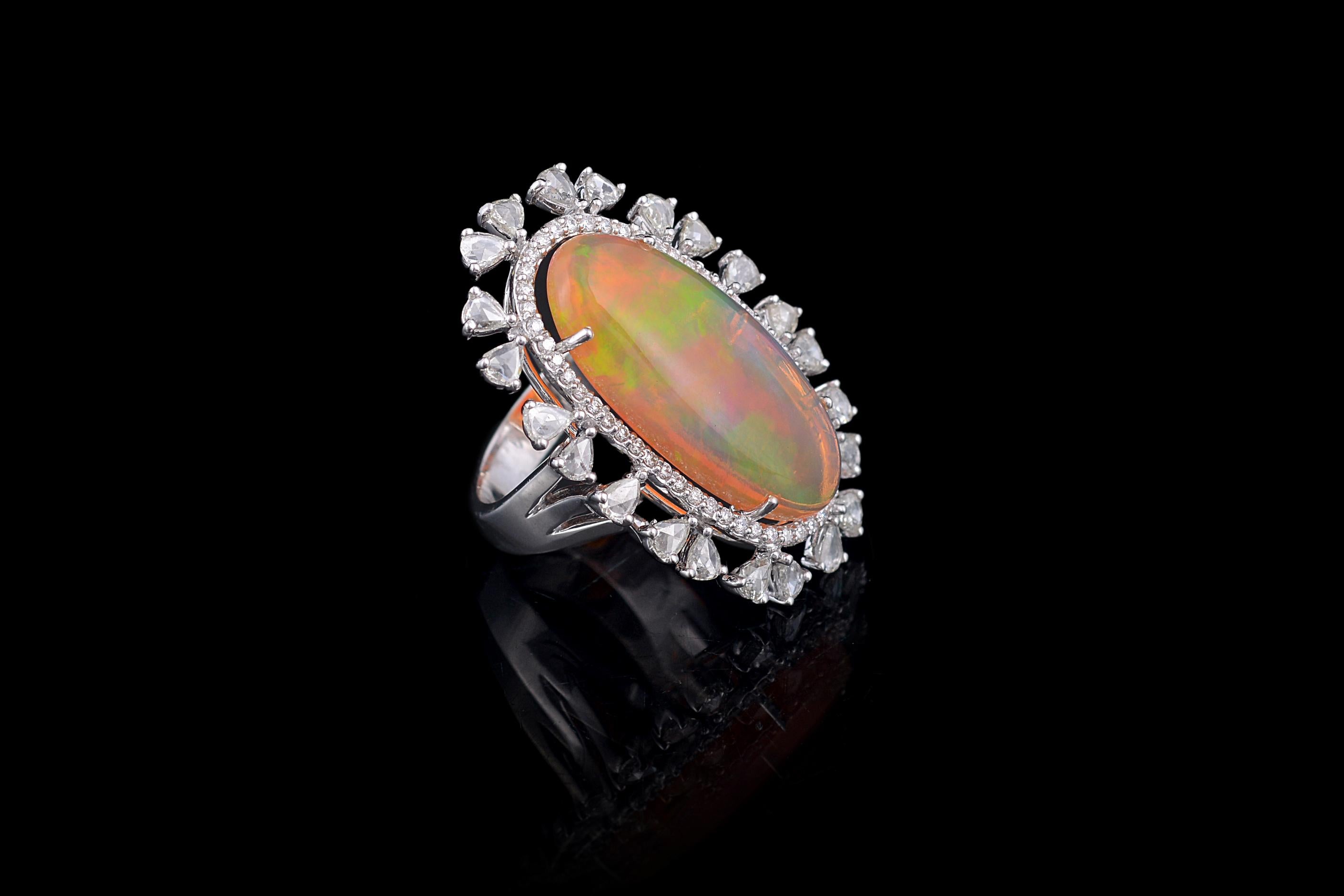 A gorgeous Opal and Rose cut Diamond cocktail ring set in 18K white gold. The opal, of Ethiopian origin, has a transparent water opal like colour and displays a orange - green play of colour. The weight of the opal is 8.28 carats. The weight of the