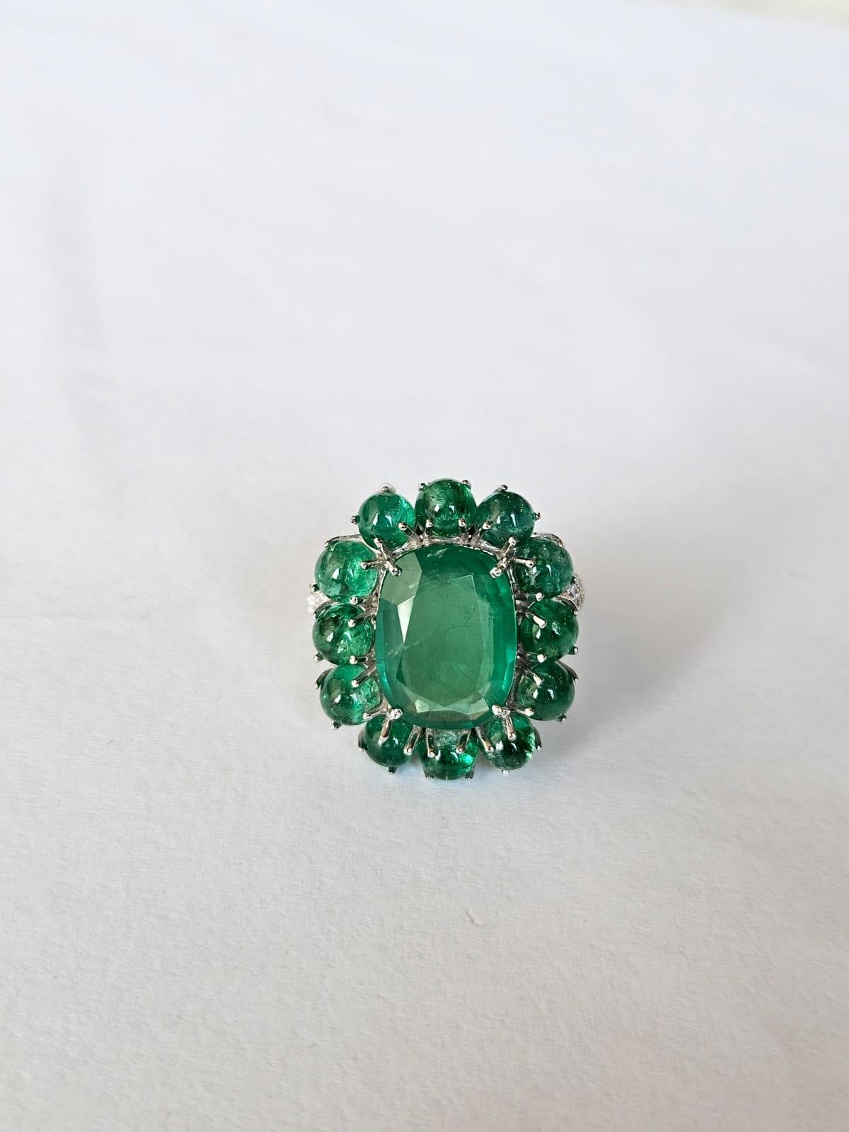 A very gorgeous and beautiful, Emerald Cocktail Ring set in 18K White Gold & Diamonds. The weight of the centre Emerald is 4.56 carats. The weight of the Emerald Cabochons is 5.60 carats. Both Emeralds are completely natural, without any treatment