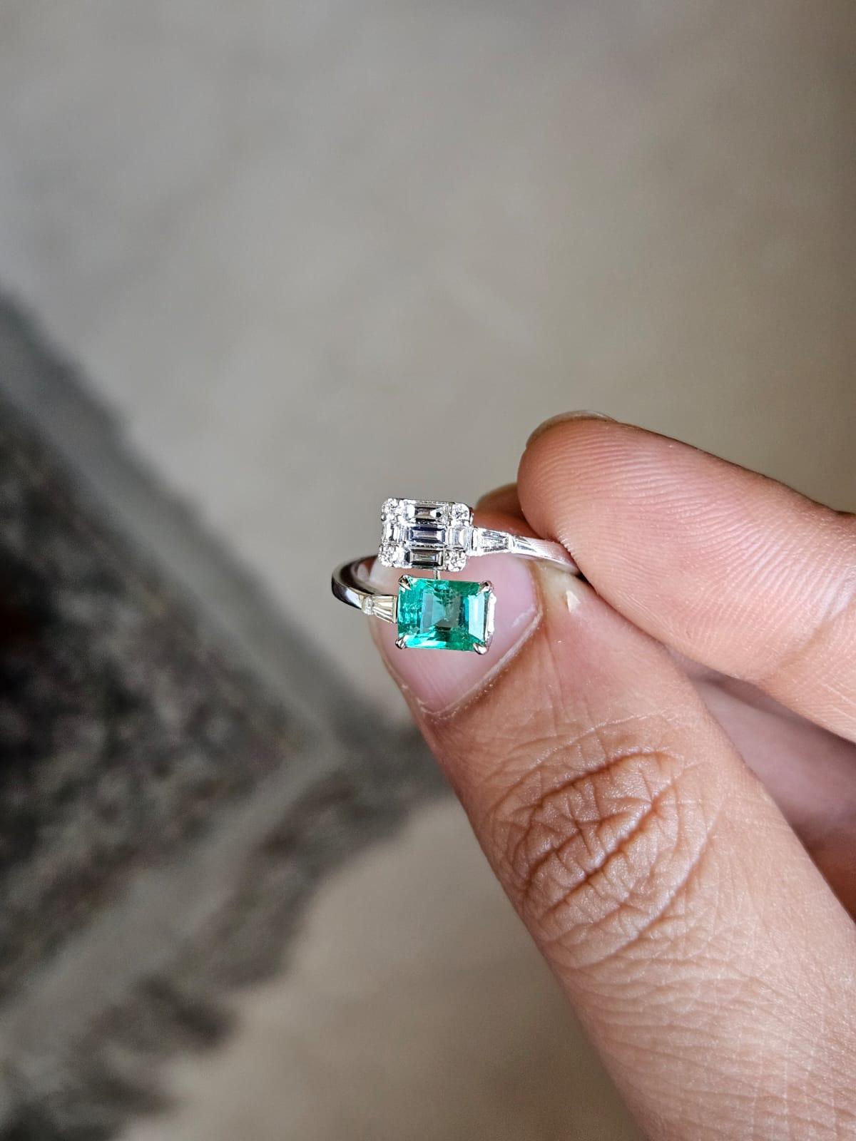 A very gorgeous and beautiful, modern style, Emerald Engagement Ring set in 18K White Gold & natural Diamonds. The weight of the Emerald is 1.10 carats. The Emerald is completely natural, without any treatment and is of Zambian origin. The Diamonds