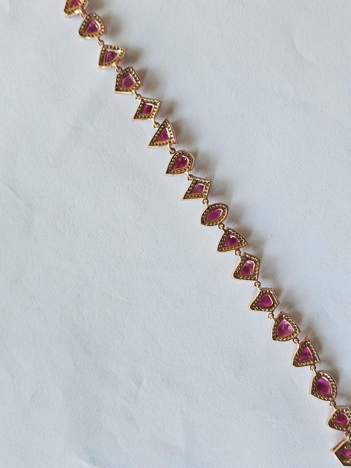 A very gorgeous and modern, one of a kind, Ruby Tennis Bracelet set in 18K Rose Gold & Diamonds. The weight of the uneven shaped Rubies is 11.38 carats. The Rubies are completely natural, without any treatment. The Diamonds weight is 1.67 carats.