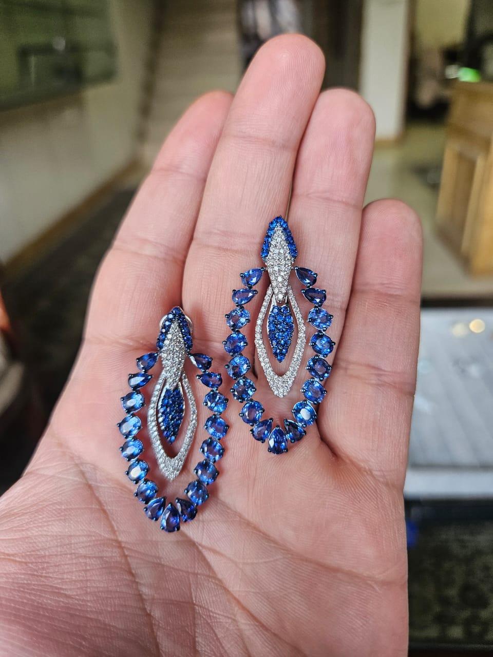 A very gorgeous and beautiful, modern style, Blue Sapphires Dangle Earrings set in 18K White Gold & natural Diamonds. The combined Blue Sapphires weight is 11.42 carats. The Blue Sapphires are of Ceylon (Sri Lankan) origin. The Diamonds weight is