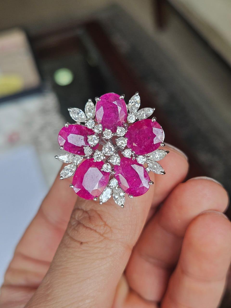 Un bellissimo anello da cocktail in rubino con oro 18 carati e diamanti naturali. Il peso dei rubini è di 11.84 carati. I rubini sono completamente naturali, senza alcun trattamento e sono di origine mozambicana. Il peso dei diamanti è di 2,64