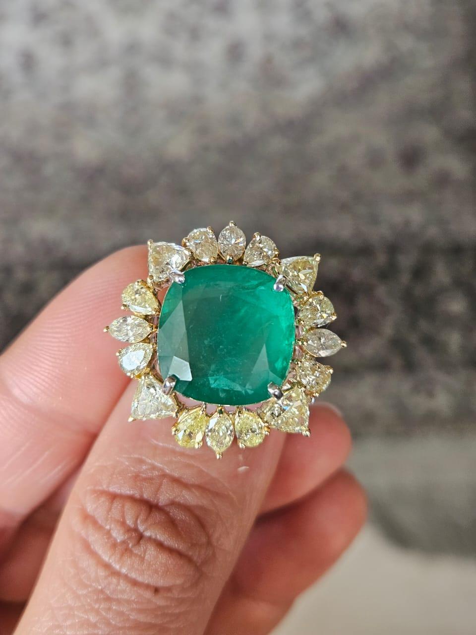 A very stunning and gorgeous, modern style, Emerald Cocktail Ring set in 18K Yellow Gold & natural Yellow Diamonds. The weight of the Emerald is 12.60 carats. The Emerald is completely natural, without any treatment and is of Zambian origin. The