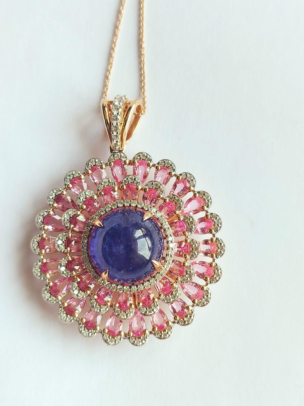 A very gorgeous and one of a kind, Tanzanite & Pink Sapphire Modern style Pendant Necklace set in 18K Gold & Diamonds. The weight of the Tanzanite cabochon is 13.10 carats. The Tanzanite is responsibly sourced from Tanzania. The weight of Pink