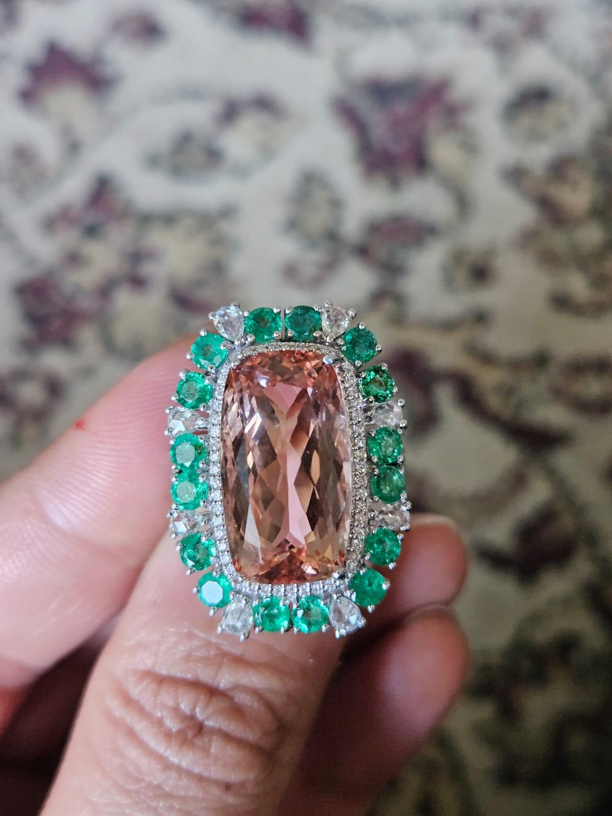 A very gorgeous and beautiful, Morganite & Emerald Cocktail Ring set in 18K Gold & diamonds. The weight of the Morganite is 13.37 carats. The weight of the Emeralds is 2.07 carats. The Emeralds are completely natural, without any treatment and are
