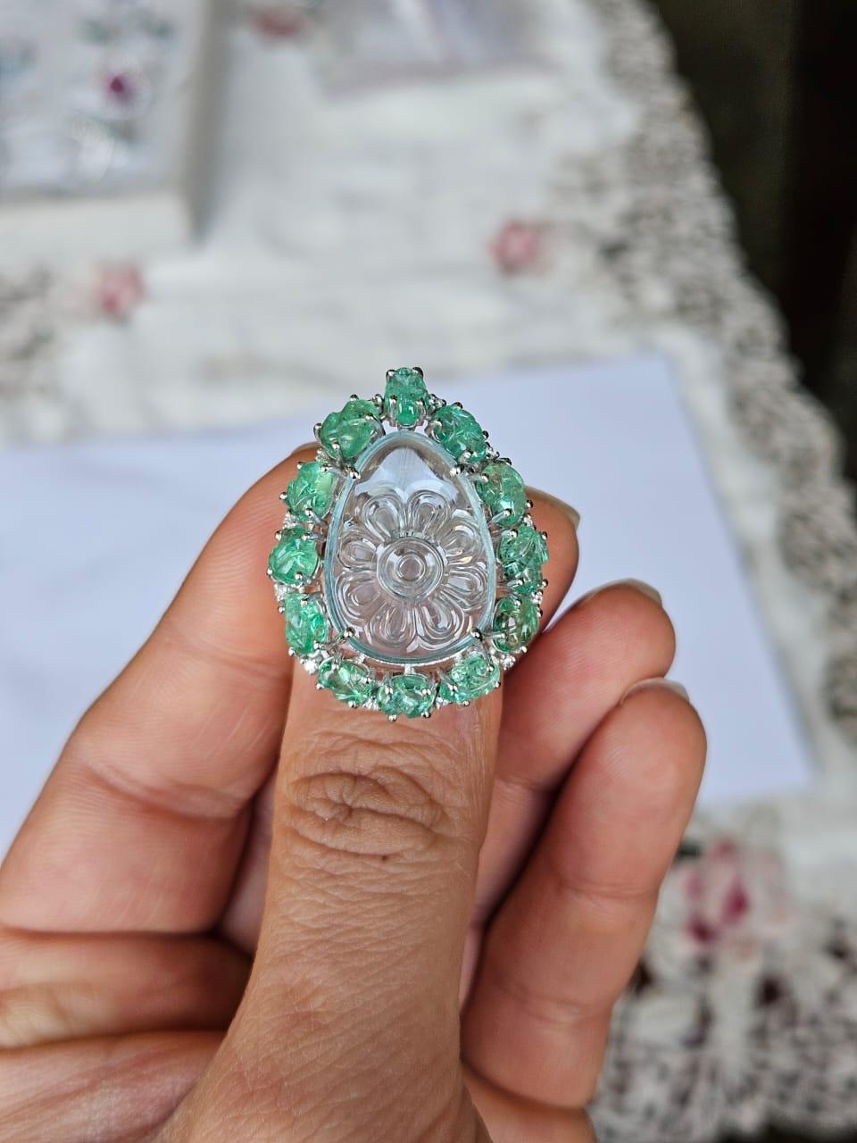 A very gorgeous and beautiful, one of a kind, Aquamarine & Emeralds Cocktail Ring set in 18K White Gold & natural Diamonds. The weight of the carved Aquamarine is 13.39 carats. The Aquamarine is hand-carved in our very own workshop. The weight of