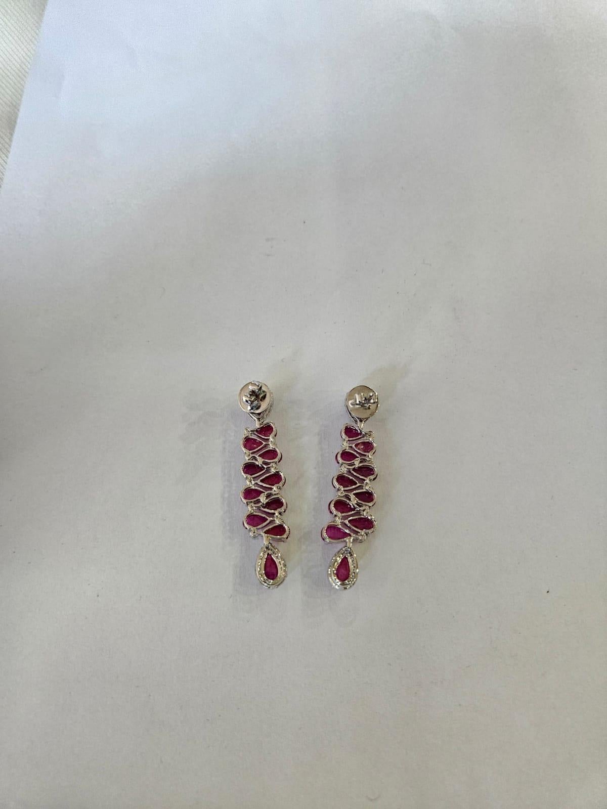Splendidi e bellissimi, in stile moderno, gli orecchini pendenti di rubino in oro bianco 18 carati e diamanti naturali. Il peso dei cabochon di rubino è di 15.48 carati. I rubini sono completamente naturali, senza alcun trattamento e sono di origine