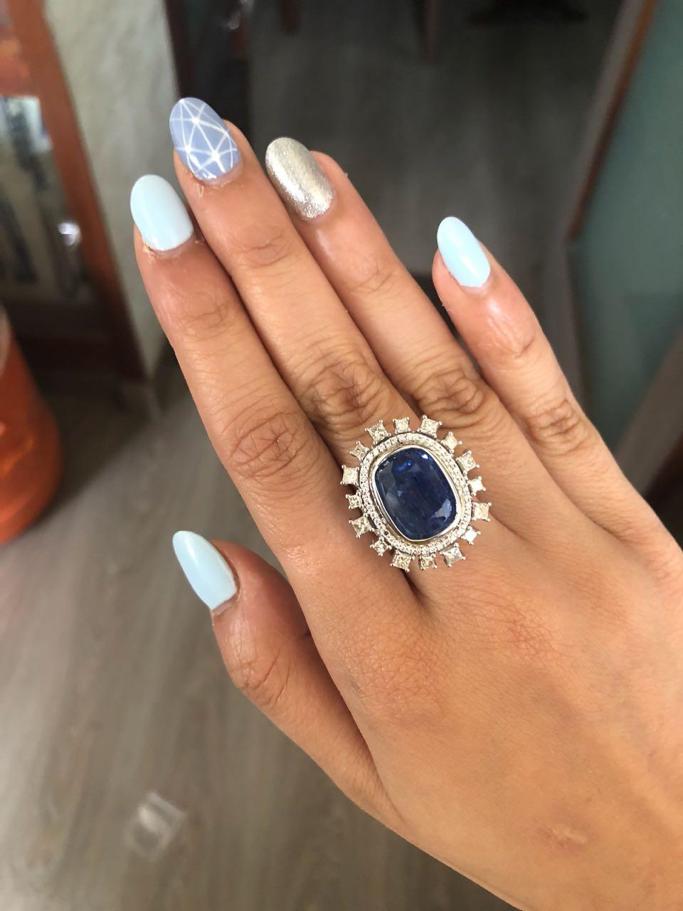 A very important and gorgeous Burma Blue Sapphire and diamond cocktail ring set in 18K white gold. The Blue Sapphire, is a Burma natural, no heat, and weighs 15.88 carats. The weight of the princess diamonds is . The ring is made in Indian ring size
