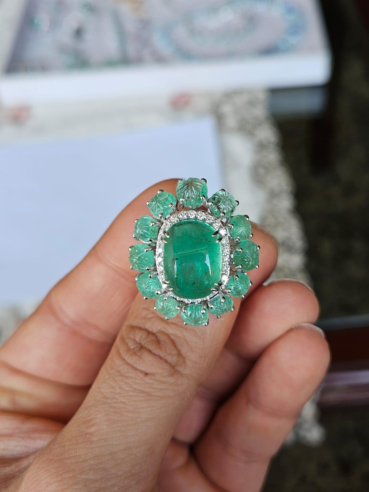 Un Anillo Cúpula de Esmeralda muy hermoso y bello, engastado en Oro Blanco de 18 quilates y Diamantes naturales. El peso del cabujón de esmeralda de forma impar es de 10,12 quilates. El peso de la Esmeralda tallada es de 5.82 quilates. Ambas