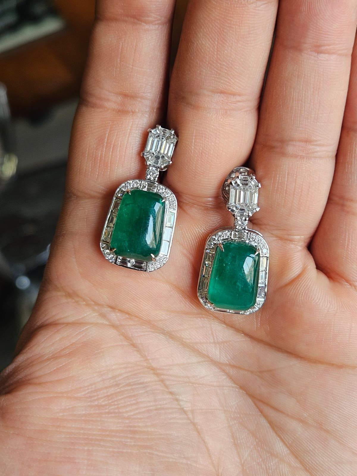 Splendidi e bellissimi, in stile moderno, gli orecchini a pendente con smeraldo in oro bianco 18 carati e diamanti naturali. Il peso degli smeraldi cabochon è di 18.70 carati. Gli smeraldi sono completamente naturali, senza alcun trattamento e sono