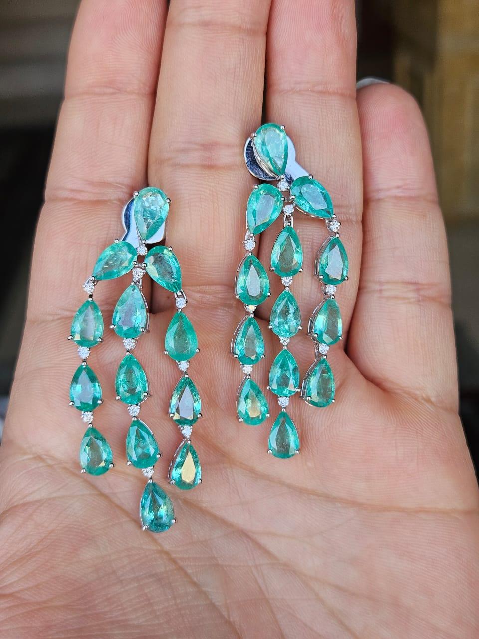 Bellissimi orecchini a pendente con smeraldo, in stile moderno, realizzati in oro bianco 18 carati e diamanti naturali. Il peso degli smeraldi è di 20,33 grammi. Gli smeraldi sono completamente naturali, senza alcun trattamento e sono di origine