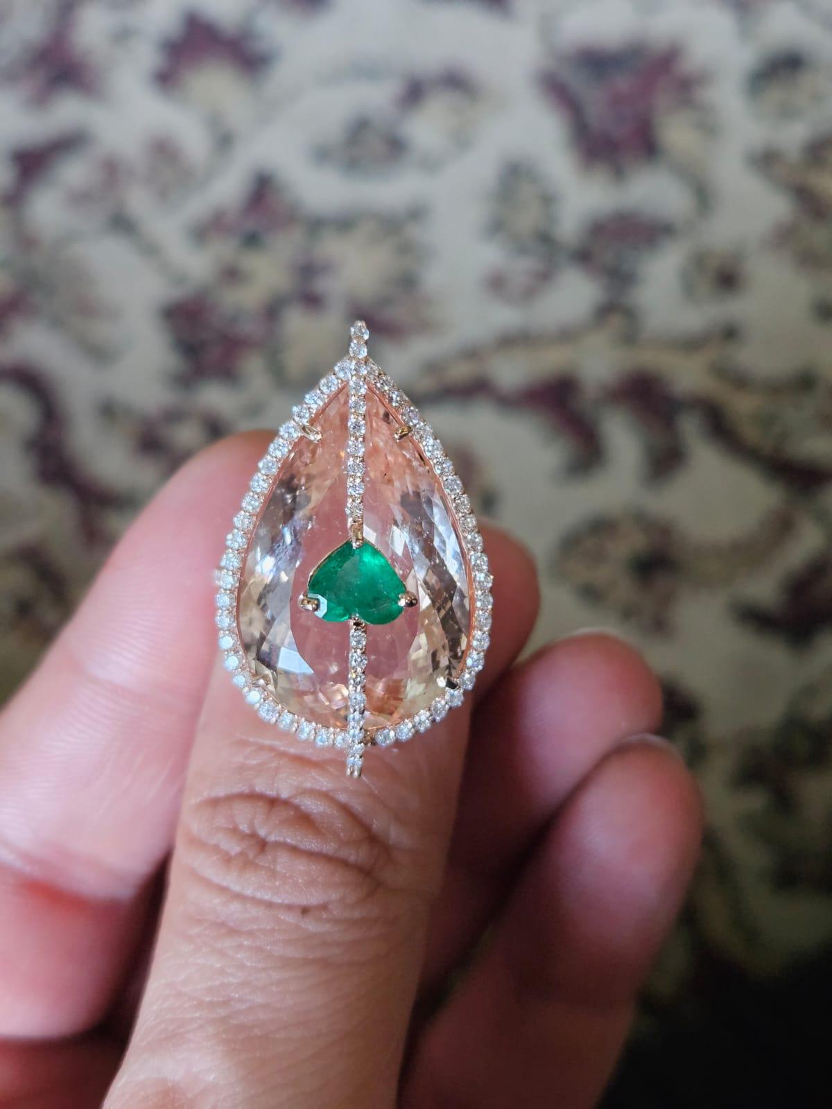A very gorgeous and one of a kind, modern style, Morganite & Emerald Cocktail Ring set in 18K Rose Gold & Diamonds. The weight of the pear shaped Morganite is 21.25 carats. The heart shaped Emerald weight is 0.82 carats. The Emerald is completely