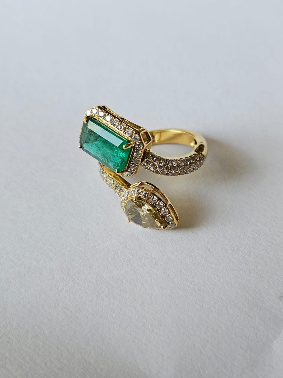 A very gorgeous and beautiful, modern style, Emerald Engagement Ring set in 18K Yellow Gold & Diamonds. The weight of the Emerald is 2.34 carats. The Emerald is completely natural, without any treatment and is of Zambian origin. The combined